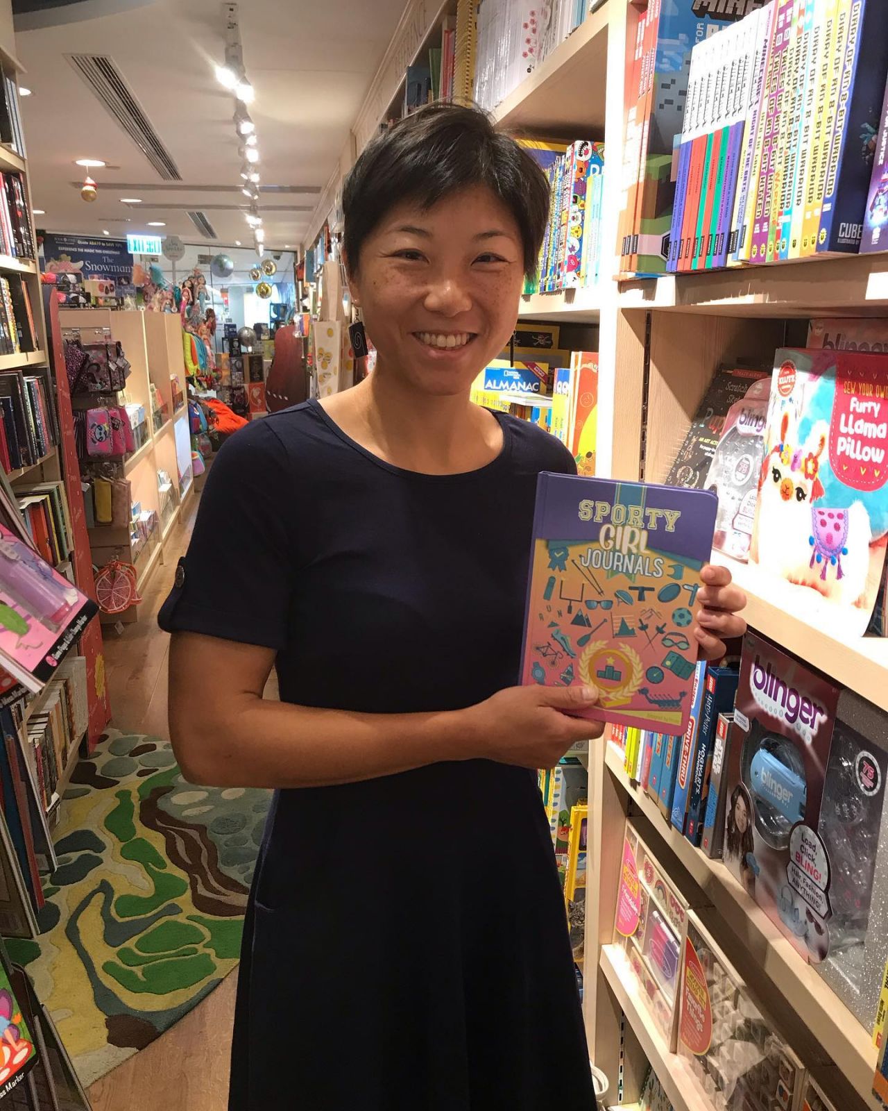 Alicia Lui with the first edition of her book, Sporty Girl Journals