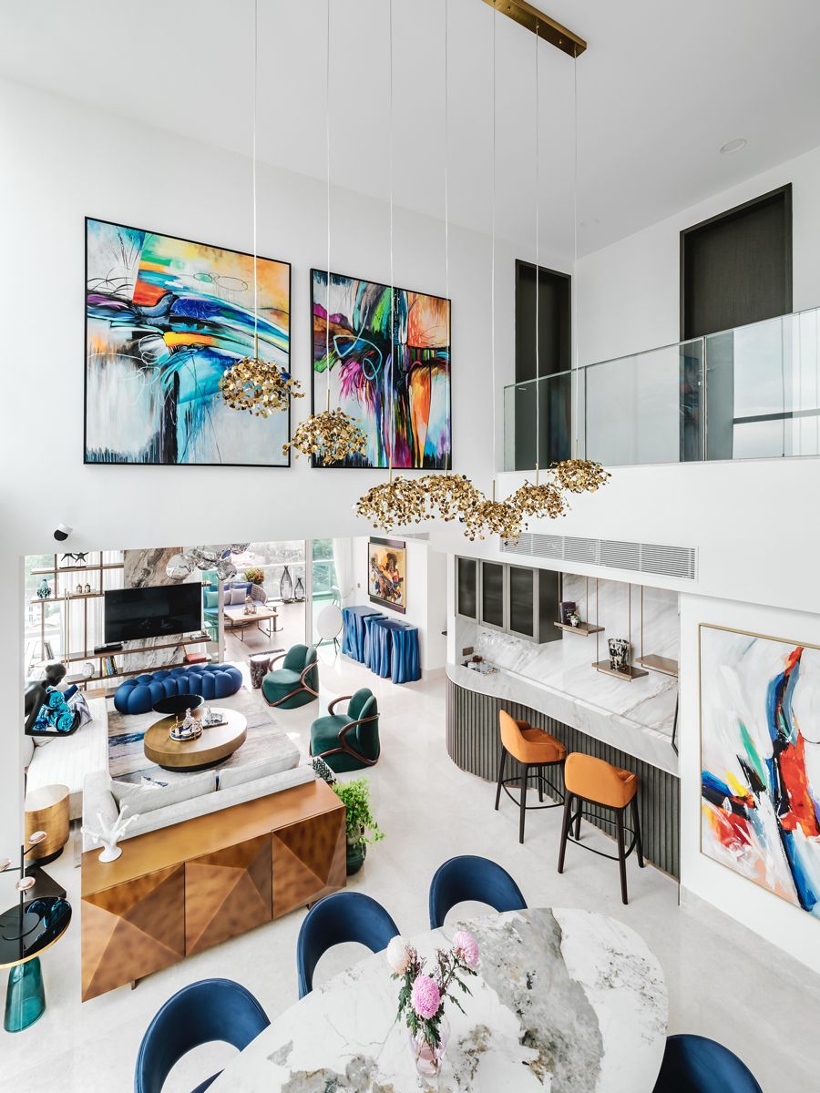 Jewel-toned furnishings echo the vibrant hues of the artworks that grace this lofty living room