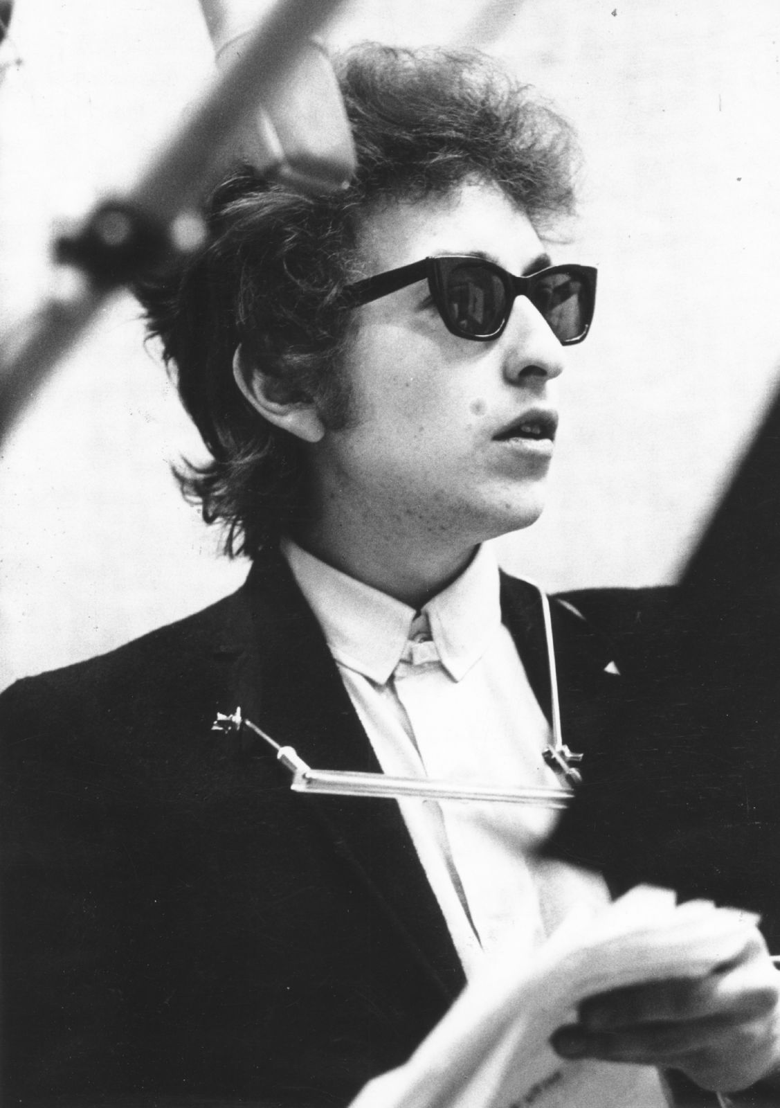 NEW YORK - JANUARY 14: Bob Dylan takes a break with the harmonica around his neck and wearing Ray-Ban sunglasses while recording his album 'Bringing It All Back Home' on January 14th, 1965 in Columbia's Studio A in New York City, New York. (Photo by Michael Ochs Archives/Getty Images)