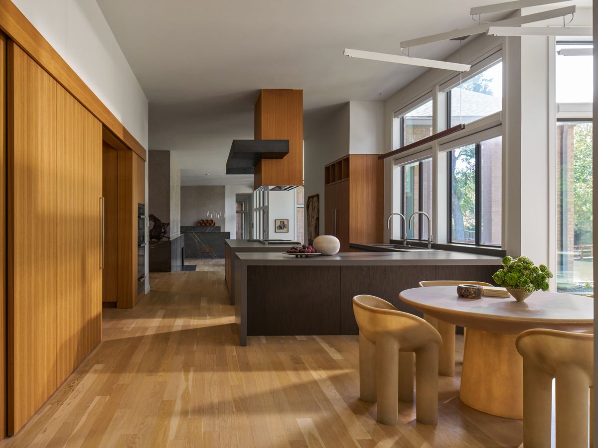 Curvy pieces balance out the clean-cut lines of the open kitchen while teak veneer brings warmth to the grey stone surfaces (Photo: Nathan Schroder)