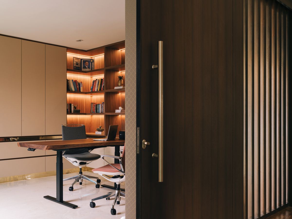 The study features stately backlit bookshelves, while subtle patterns on the walls add richness to the material palette