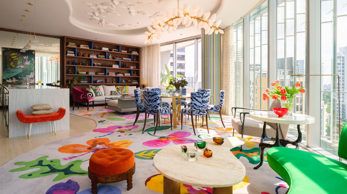 The condominium apartment's spacious and scenic living space is a gestalt of individual zones characterised by a diverse array of colourful furniture