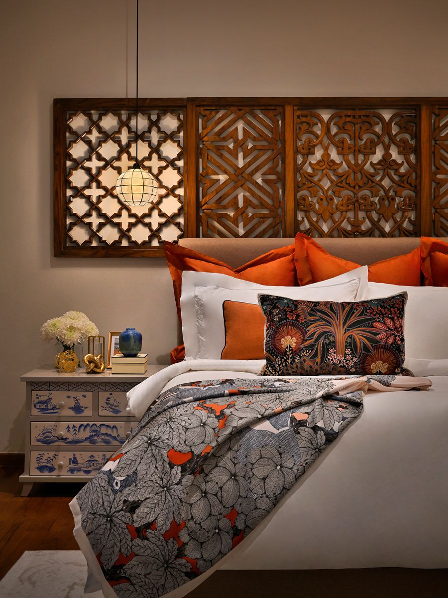 The master bedroom incorporates custom dark-stained wood panels as a headboard and soft lighting for added cosiness