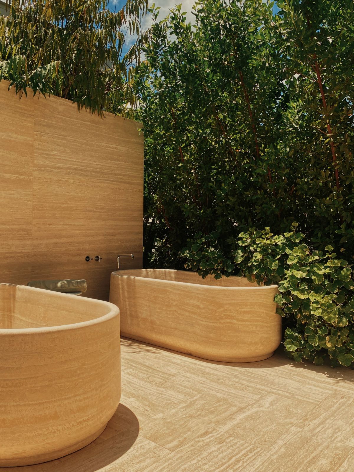 The beautiful Italian stone surfaces extend to the alfresco bathing facilities