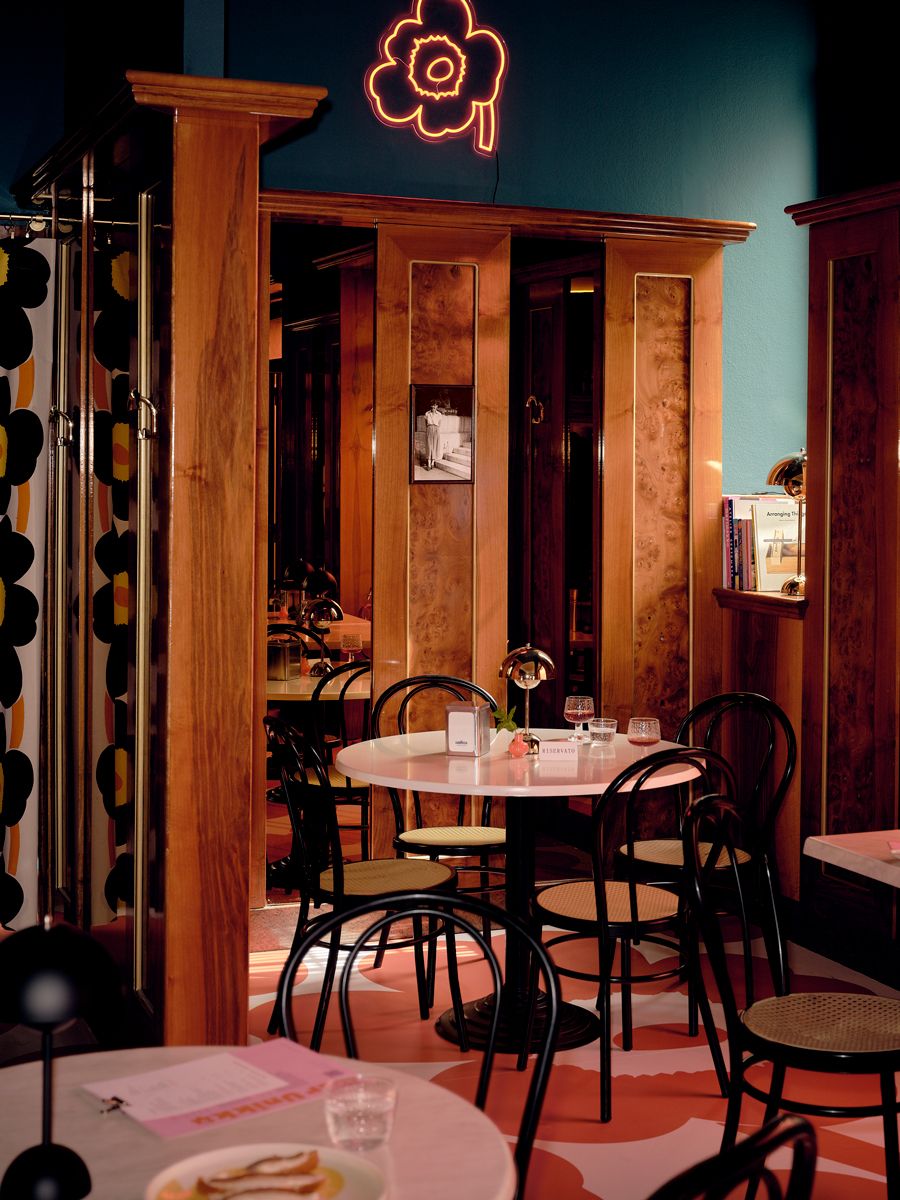 The floral print being utilised in a neon sign and floor covering at the cafe