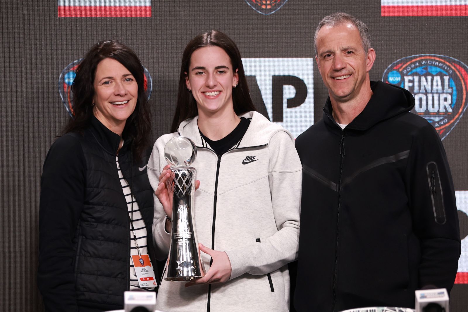 Caitlin Clark poses with her award and parents Anne Nizzi Clark and Brent Clark during a press conference ahead of the 2024 NCAA Women's Basketball Tournament Final Four in Cleveland, Ohio (Photo: Gregory Shamus/Getty Images)