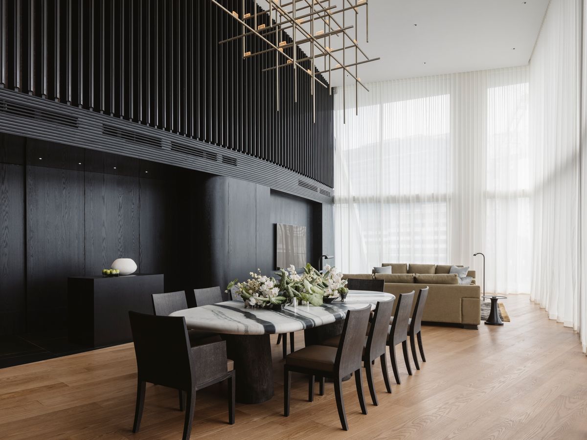 The lofty height of the double-volume living and dining areas is emphasised by an angular suspension light (Photo: Studio Periphery)