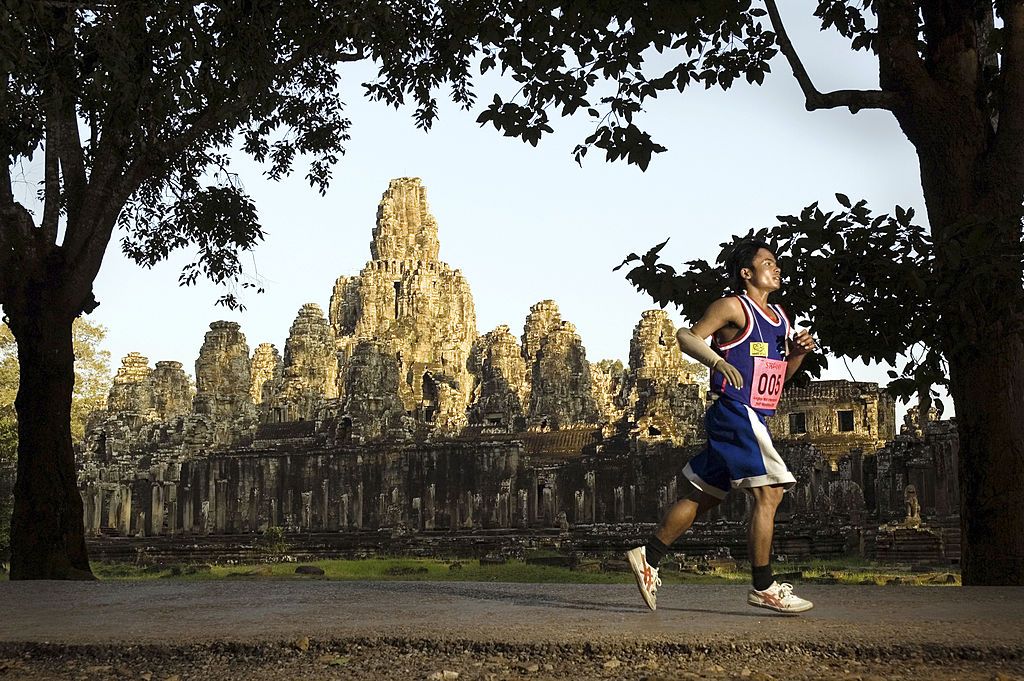 SIEM REAP, CAMBODIA - 2005/11/20: A competitor in the 10km race for amputees portion of the 10th Annual Angkor Wat International Half Marathon passes the Bayon Temple in the Angkor Archaeological Park. Competitors from around the world arrived for the event.. (Photo by Jerry Redfern/LightRocket via Getty Images)