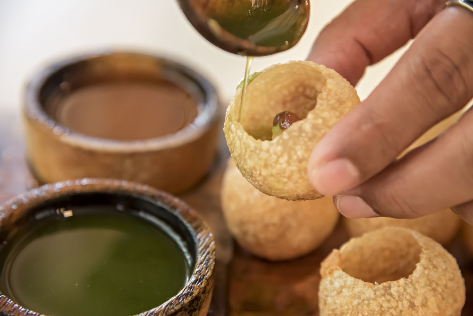 Pani puri being filled with condiments (Photo: Getty Images)