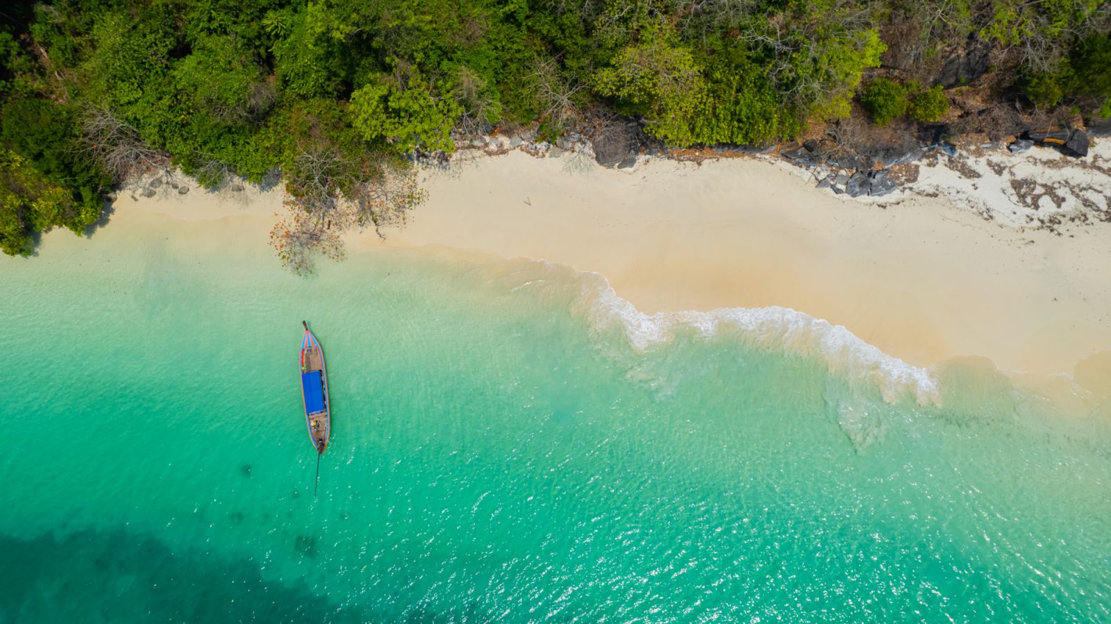 Sandy beach with beautiful sea water and long-tail boats on the pristine white beach of Bat Island in the Andaman Sea of Ranong Province, southern Thailand, Asia