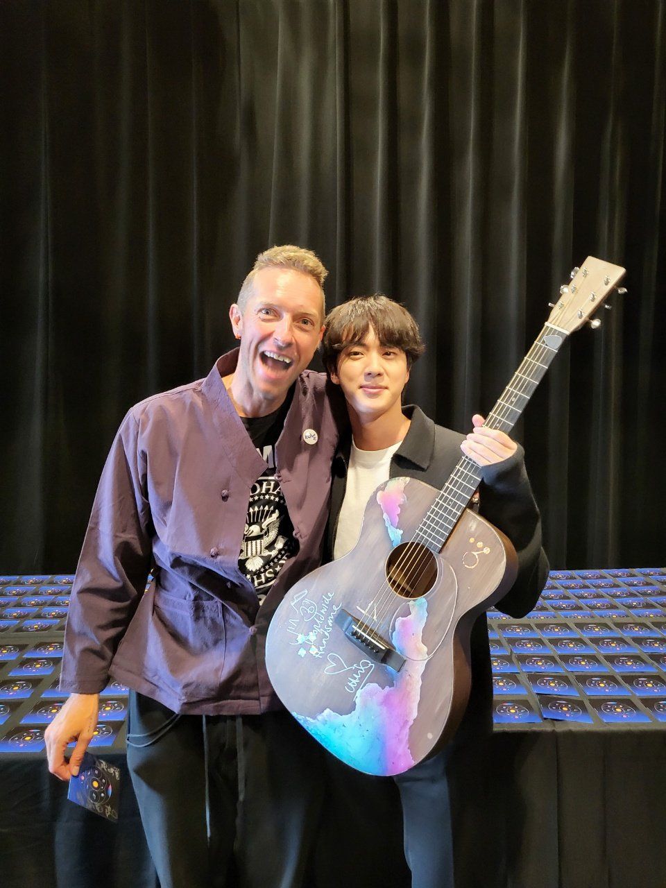 Chris Martin giving Jin a signed guitar (image courtesy of X / @bts_bighit)