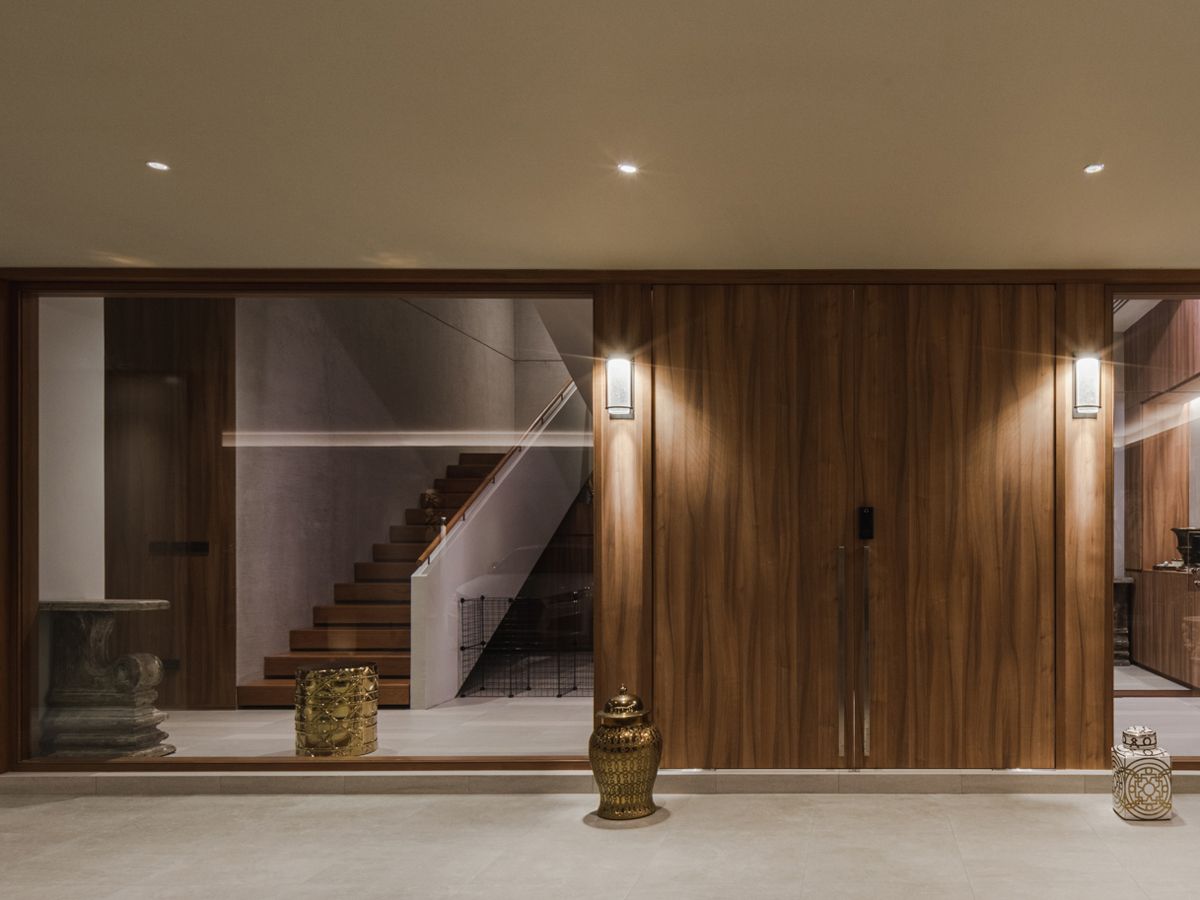 The house entrance features glass panels to invite more natural light