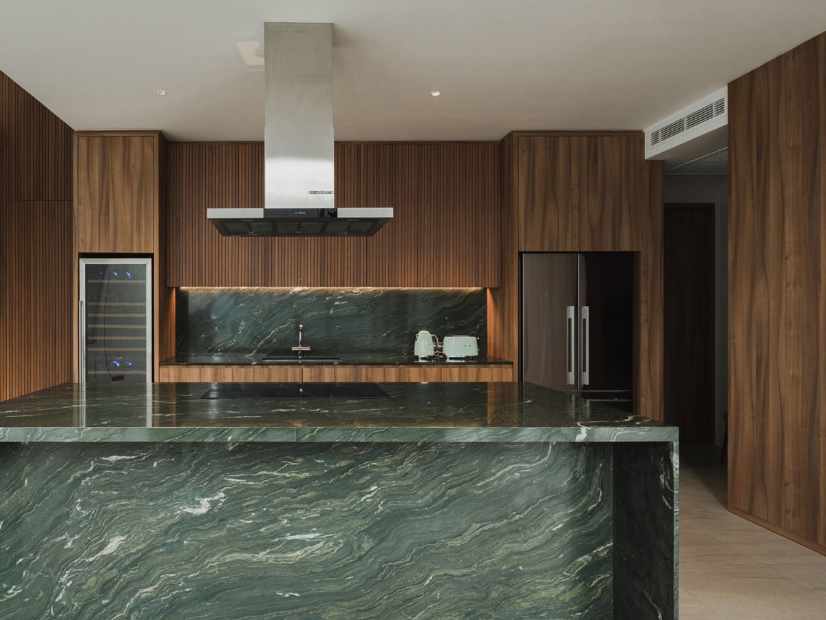 Luxurious Picasso green granite and dark-stain wood carpentry lend the kitchen area in the house a touch of elegance and cosiness