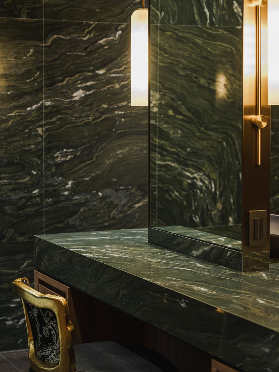 The use of luxurious Picasso green granite, such as in this master bedroom's walk-in dresser, alludes to the deep green of forests