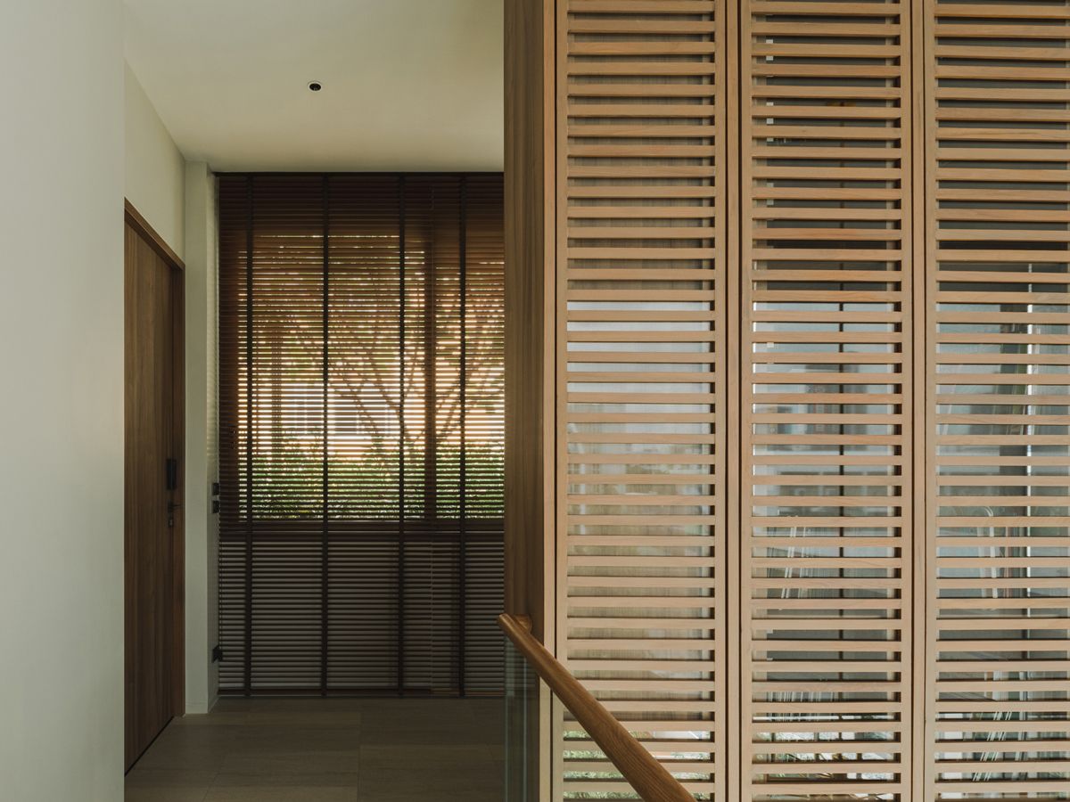 Double-height timber slat cabinets with doors opening to the corridor flank this walkway