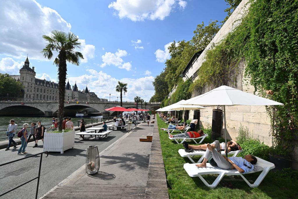 PARIS, FRANCE - AUGUST 14: Tourists and Parisians enjoy sunbathing at an artificial beach on the Paris Plages (Paris beaches) along the bank of the Seine river in Paris, France on August 14, 2023. (Photo by Mustafa Yalcin/Anadolu Agency via Getty Images)