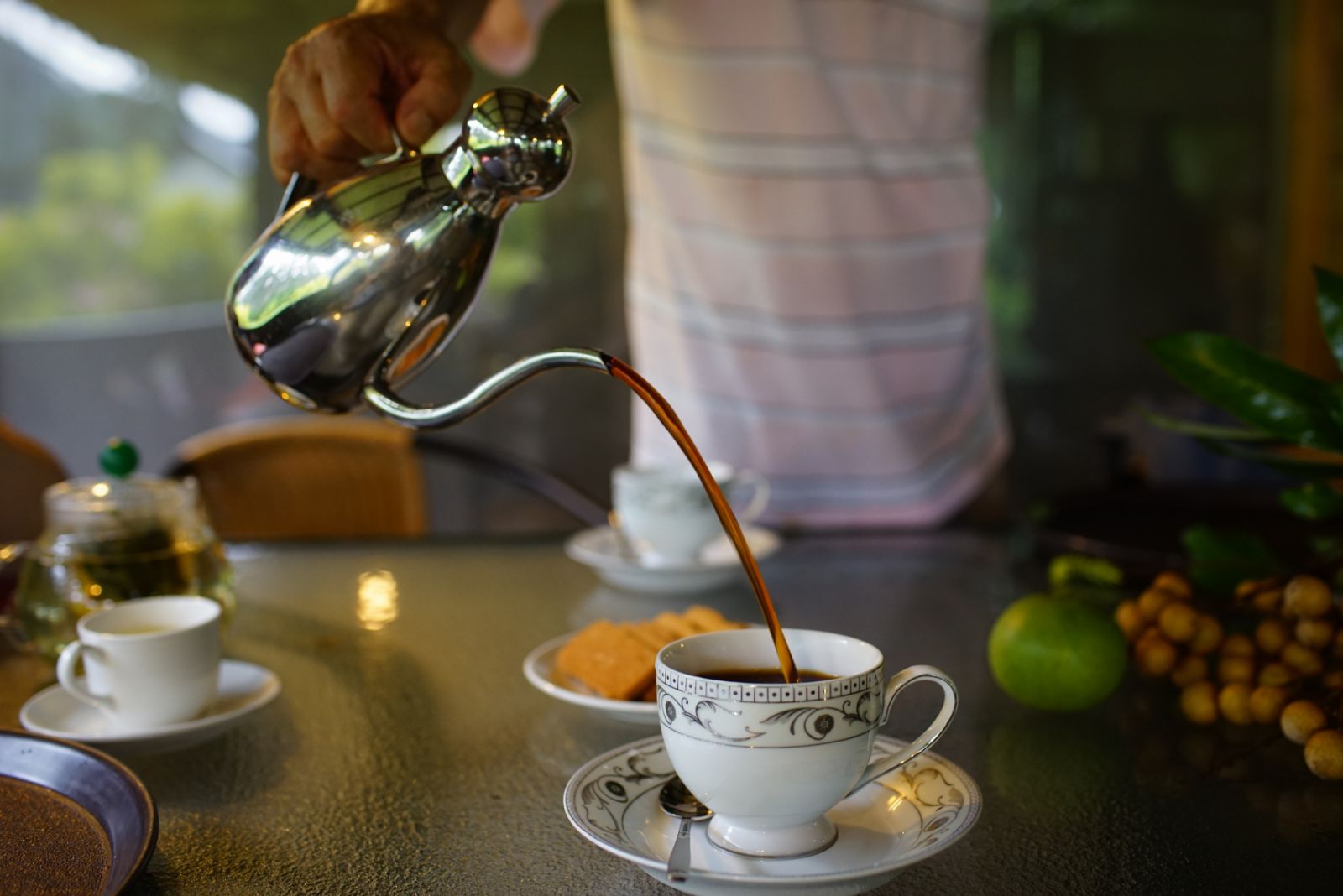 The organic coffee farm owner pouring coffee into a coffeec cup.