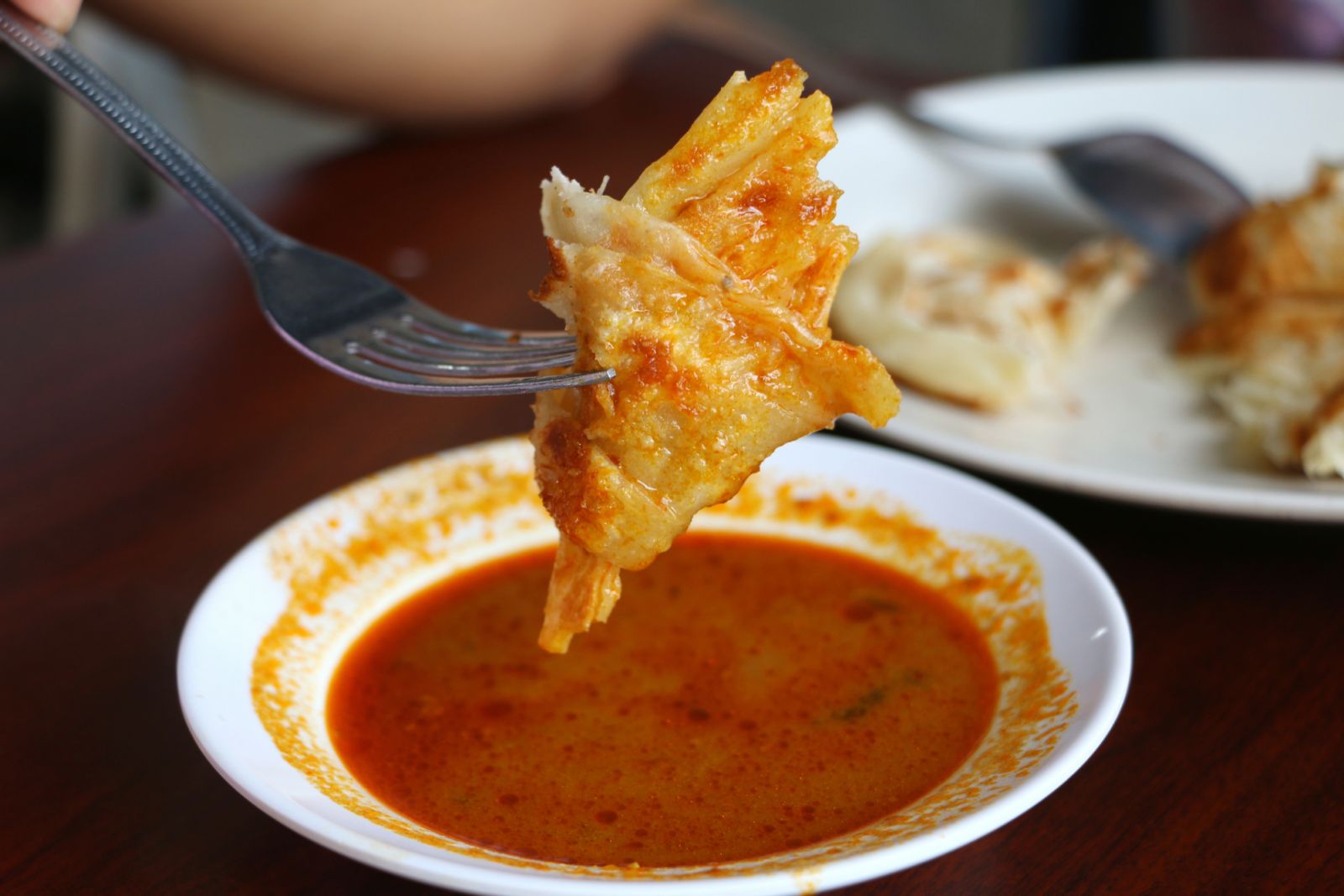Roti canai dipped in curry (Photo: Getty Images)