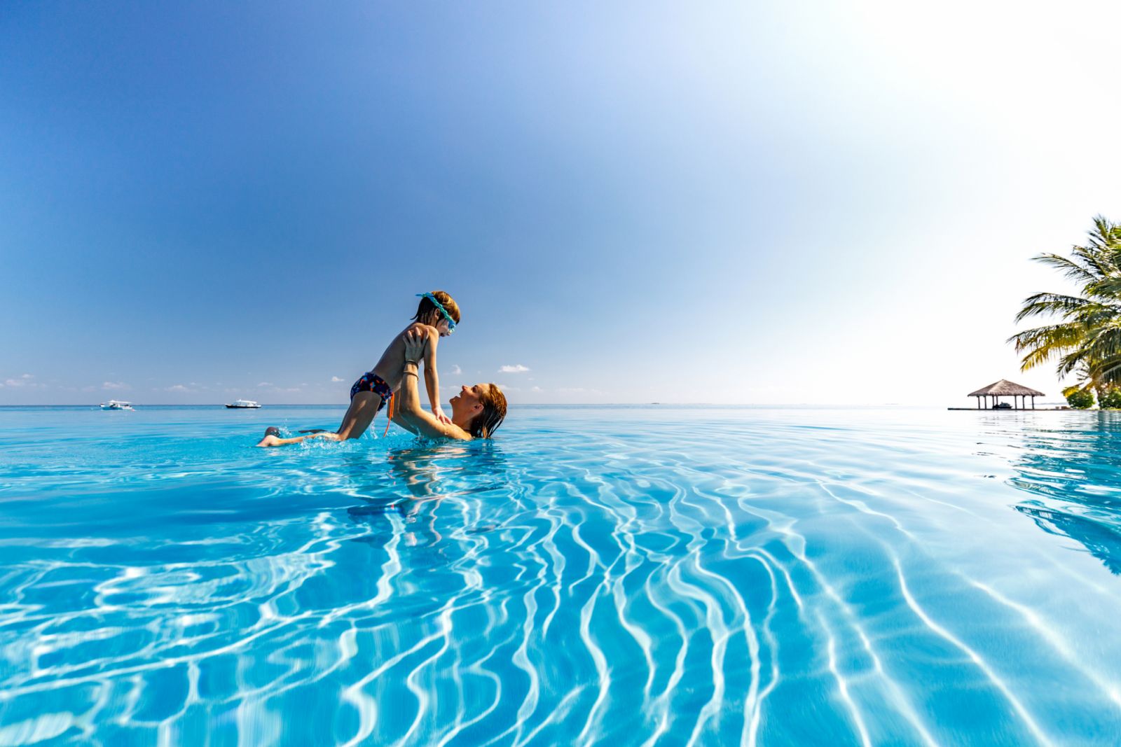Carefree boy having fun with his single mother in swimming pool. Copy space.
