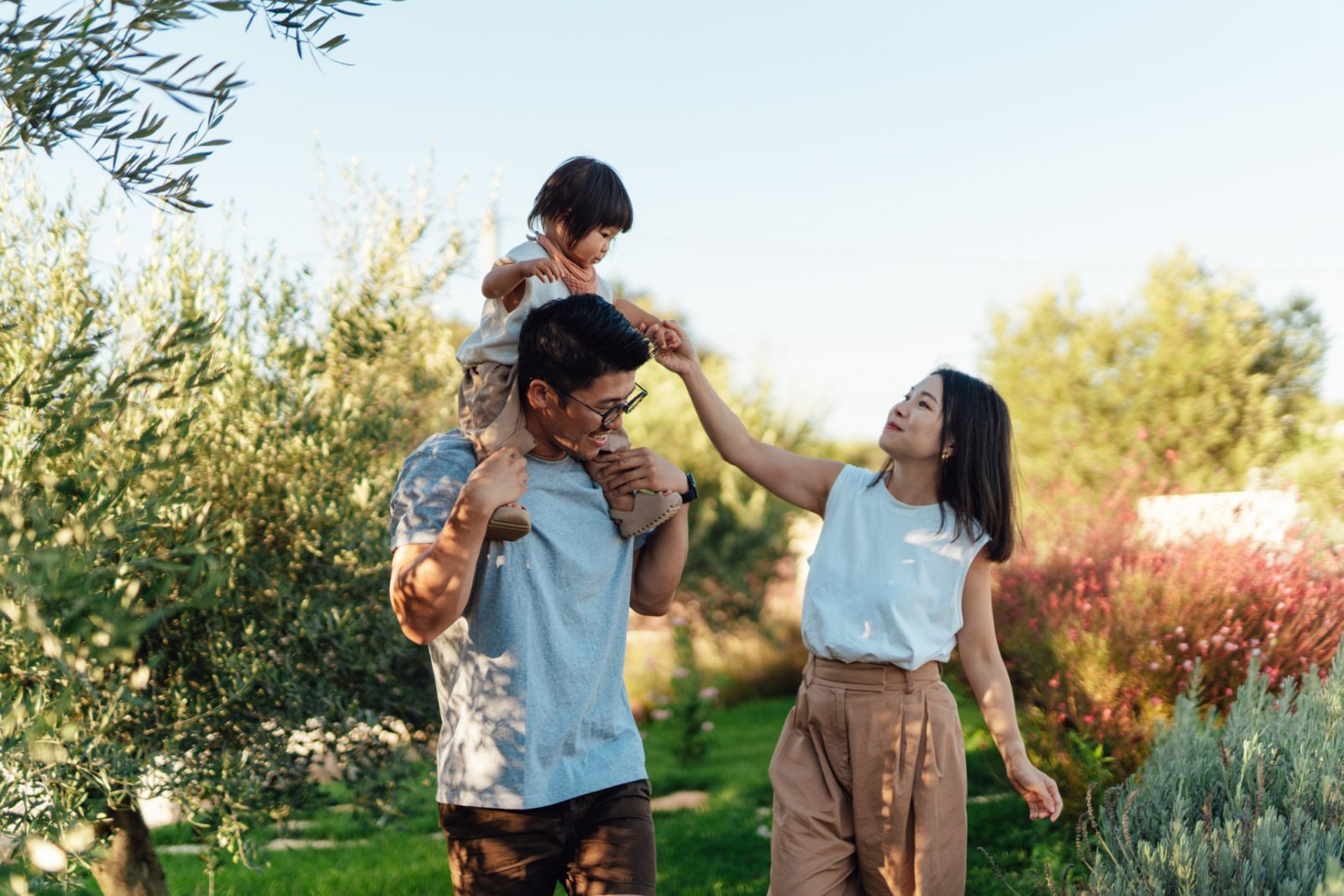 Asian father, mother and daughter spending time together in the garden. Happy and healthy family life. Teaching kids about sustainable living.