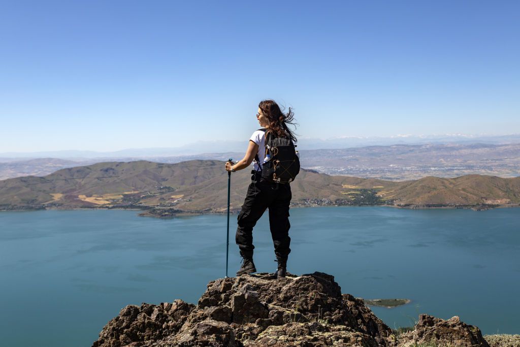 ELAZIG, TURKIYE - JUNE 13: A woman poses for a photo with the view of Hazar Lake with its 56 kilometers long shoreline between Hazarbaba and Mastar mountains in Sivrice district of Elazig, Turkiye on June 13, 2024. (Photo by Bayram Ayhan/Anadolu via Getty Images)
