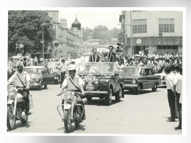 Motorcade parade in Kuala Lumpur for the 1967 Thomas Cup champions on their return, 1968. Teh Kew San and Tan Aik Huang ride with the trophy to cheers from the public (Photo: National Archives of Malaysia: Accession No. 2001/0036723W)