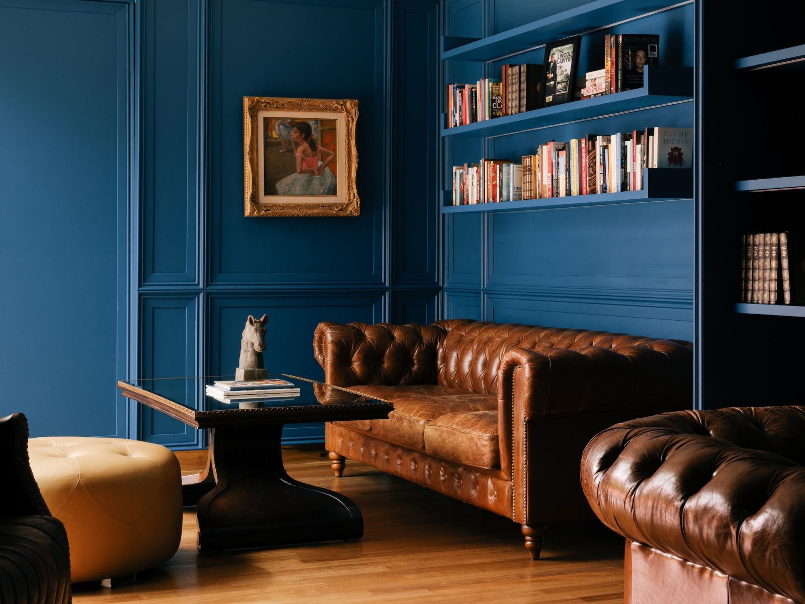 Panelled walls in blue make the gilded painting and classic Chesterfield sofa pop (Photo: MarcusL Photography)