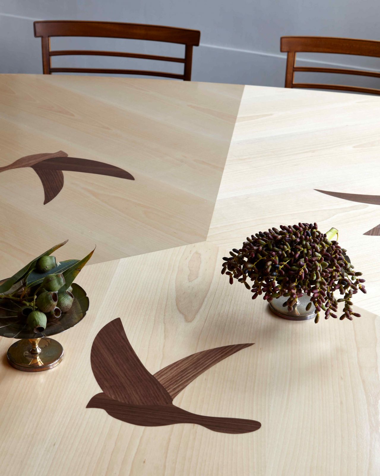 The custom ash and walnut dining table with bird motifs