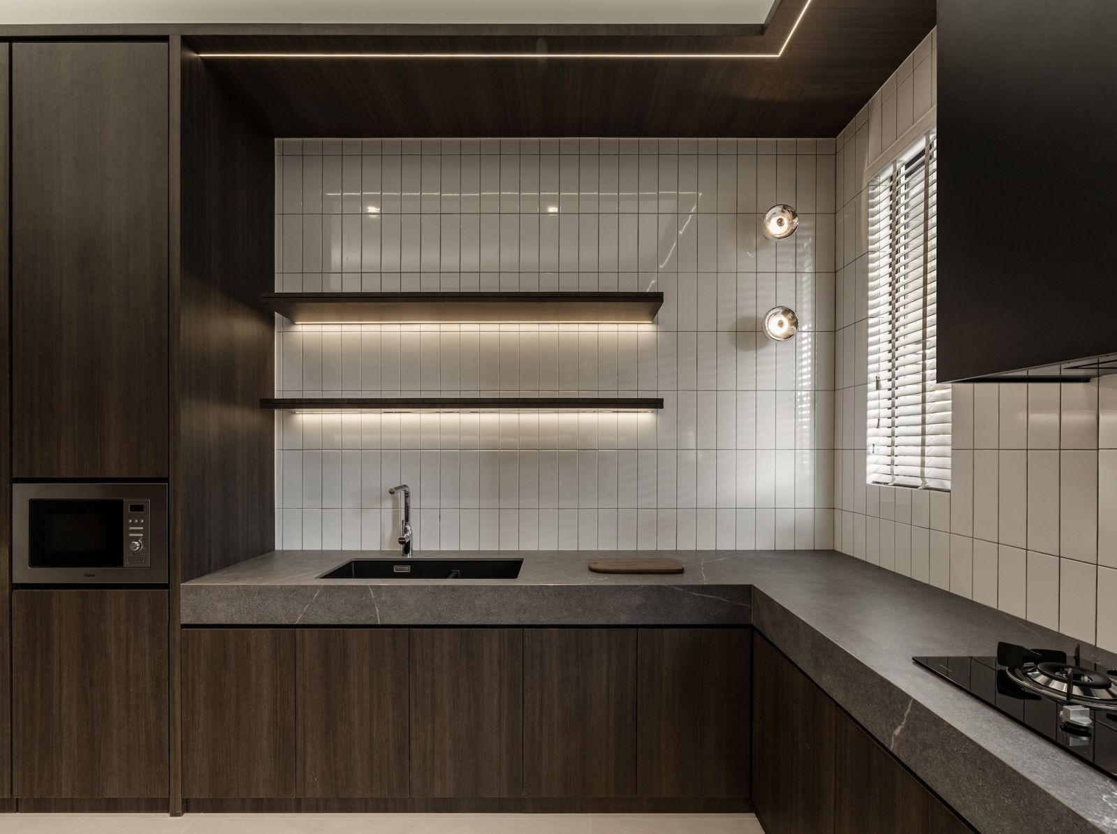 The wet kitchen is neatly realised in a darker palette