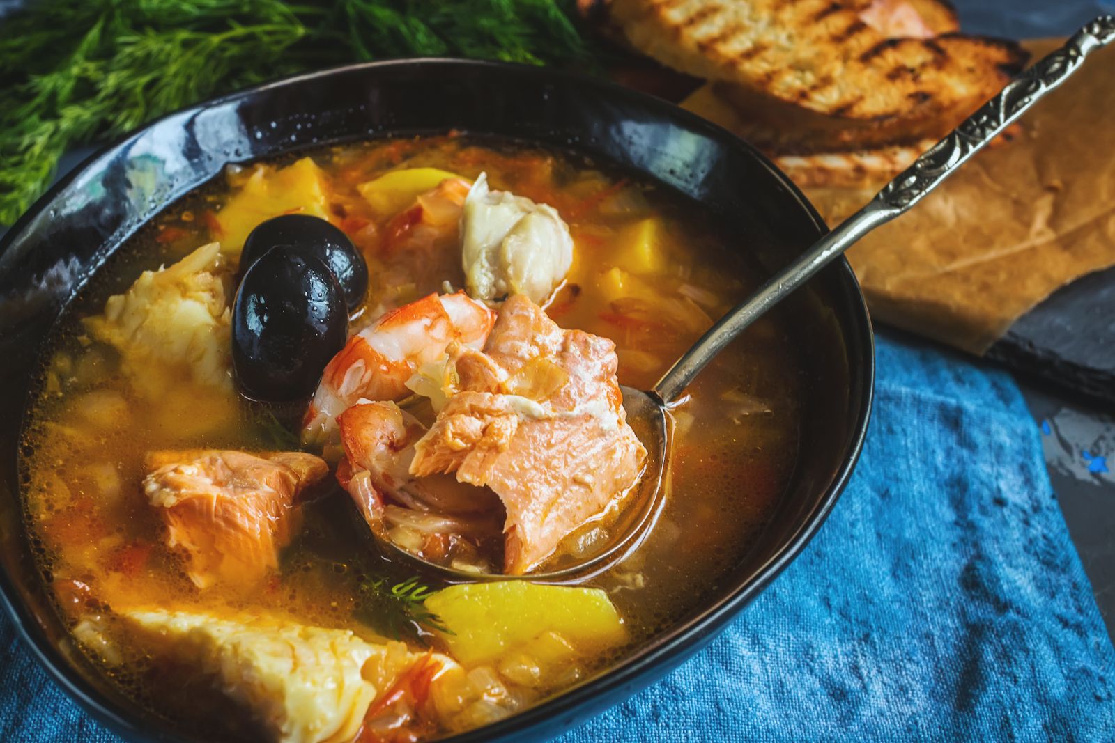 French fish soup Bouillabaisse with seafood, salmon fillet, shrimp, rich flavor, delicious dinner. Close up.