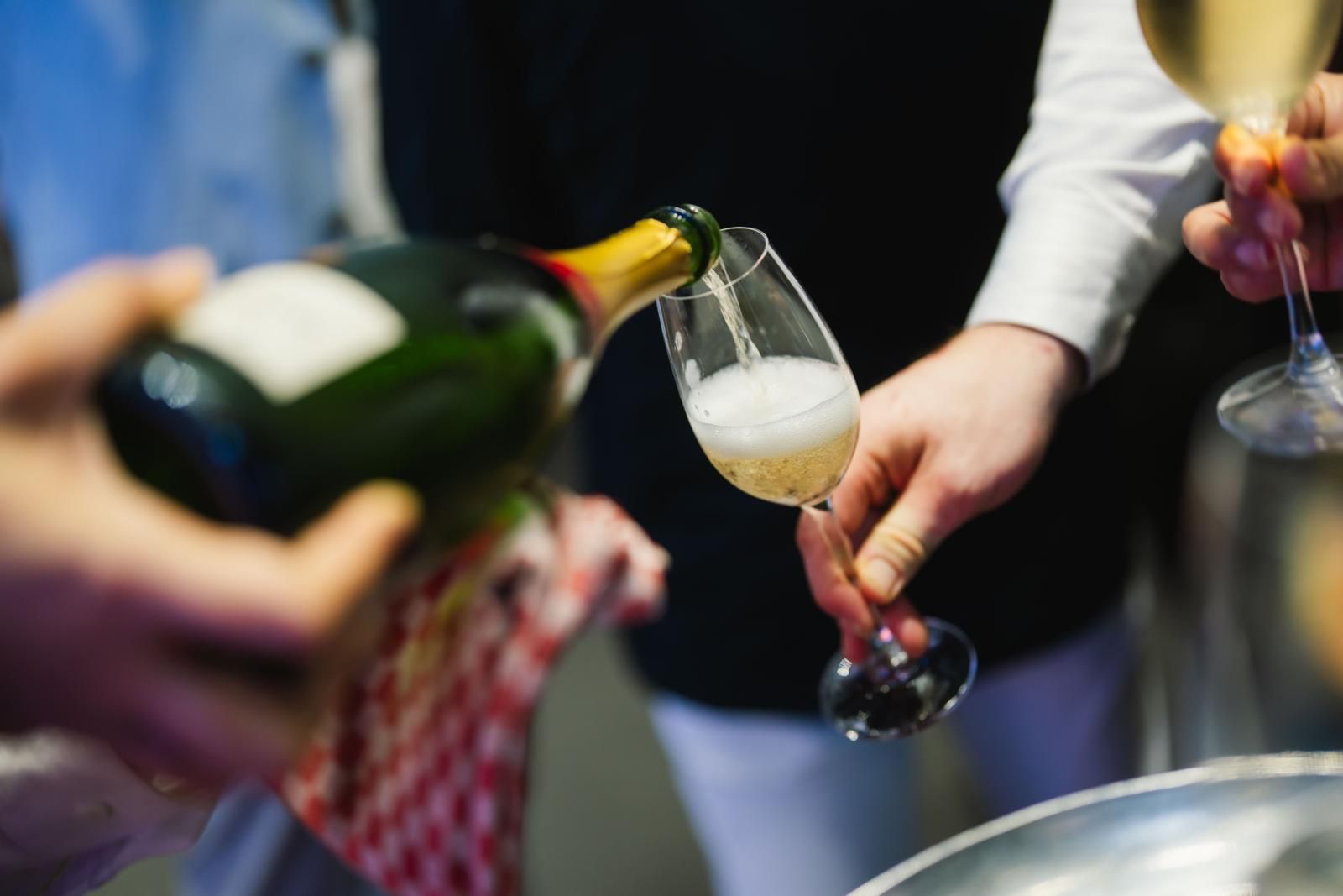 A waiter poured champagne into a glass held by a guest at Gen.T Leaders of Tomorrow 2024 launch event (Photo: Humphrey Ng)