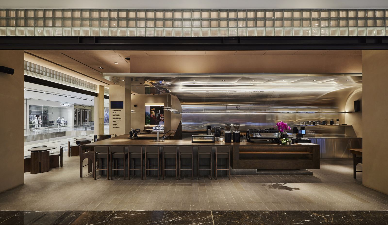 The coffee bar with a long, curved stainless steel ceiling (Photo: Okokon Studio)