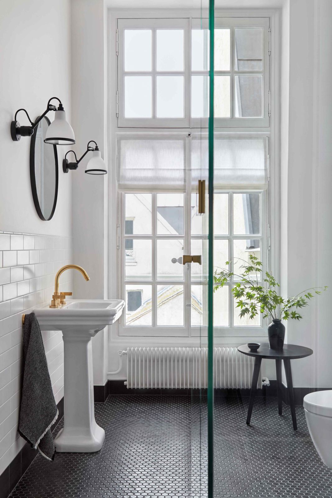 Subway tiles complement the pedestal-classic style sink