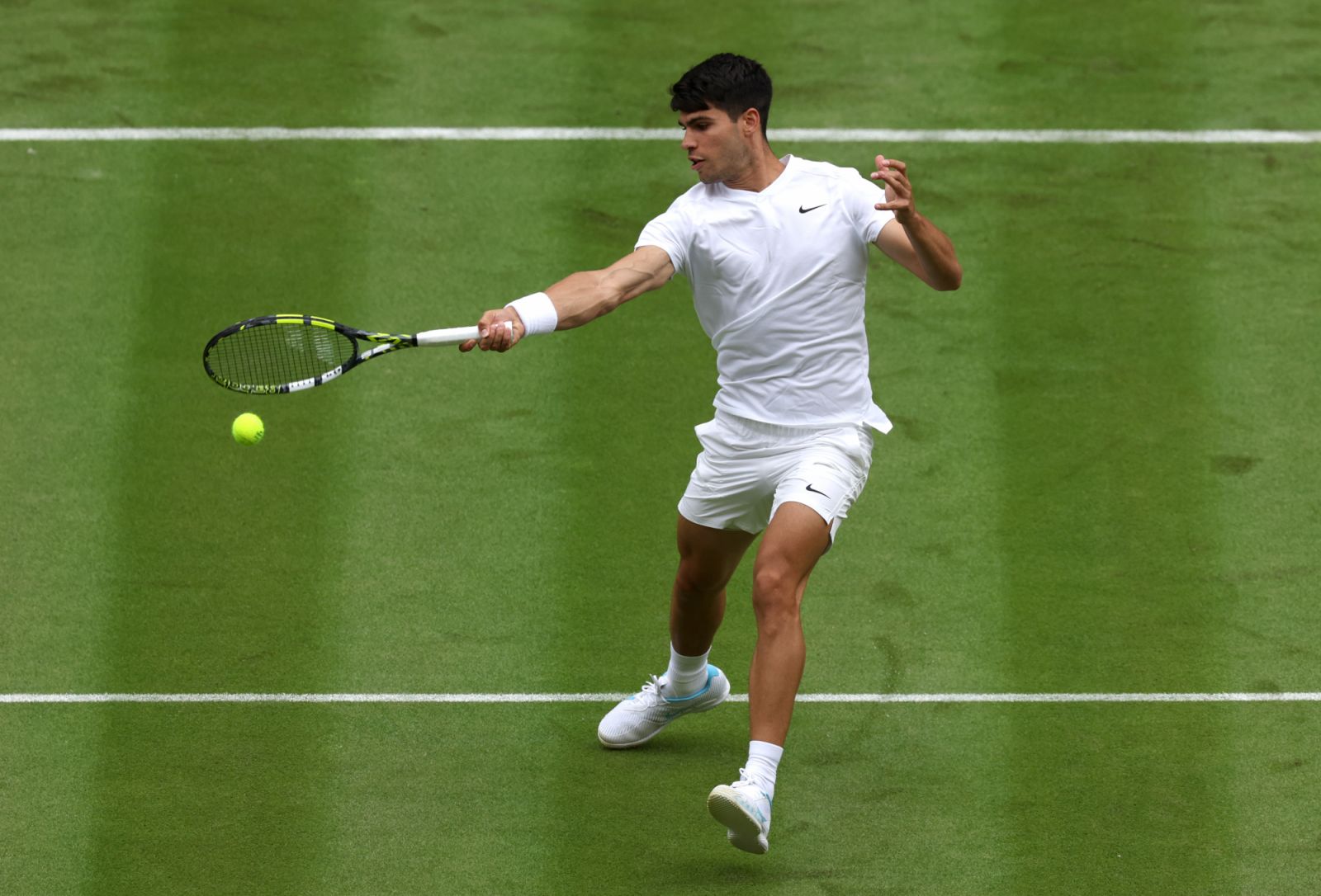 Carlos Alcaraz of Spain plays a forehand against Mark Lajal of Estonia during his Gentlemen's Singles first round match on day one of The Championships Wimbledon 2024 (Photo by Clive Brunskill/Getty Images)