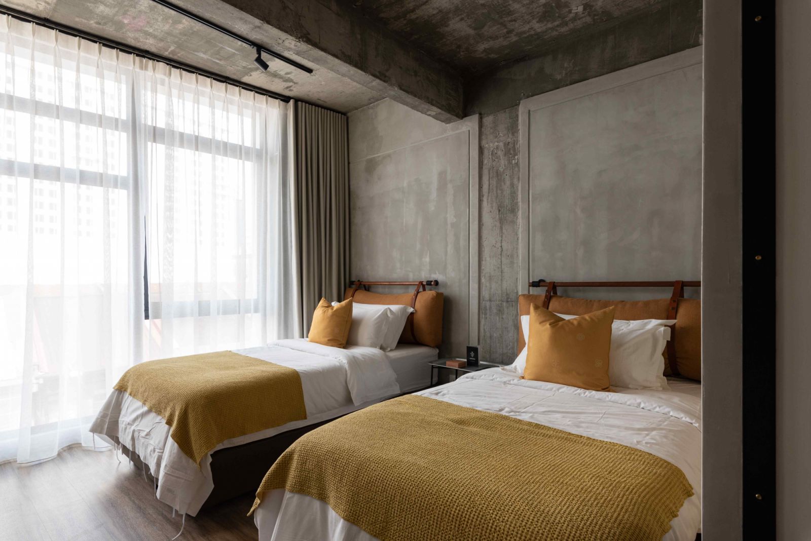 Yellow ochre upholstery echoes the lime-washed plaster walls of heritage shophouses (Photo: Courtesy of Hotel Mokozoyo)