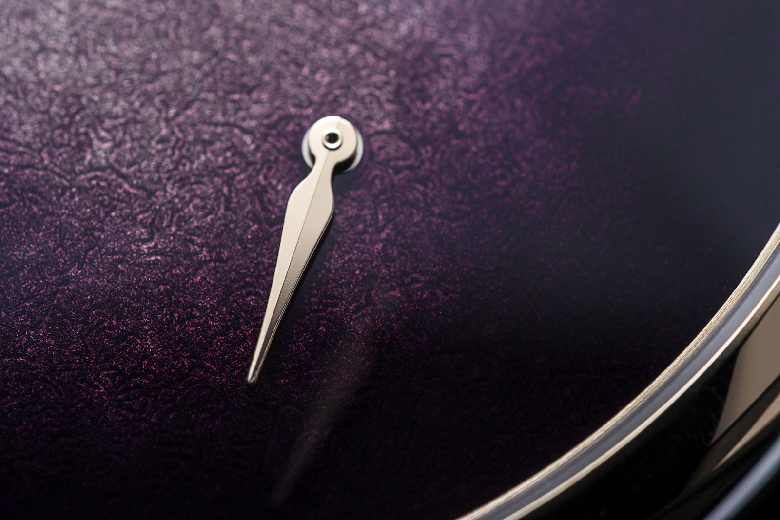 The power reserve indicator against the grand feu enamel fume dial in purple