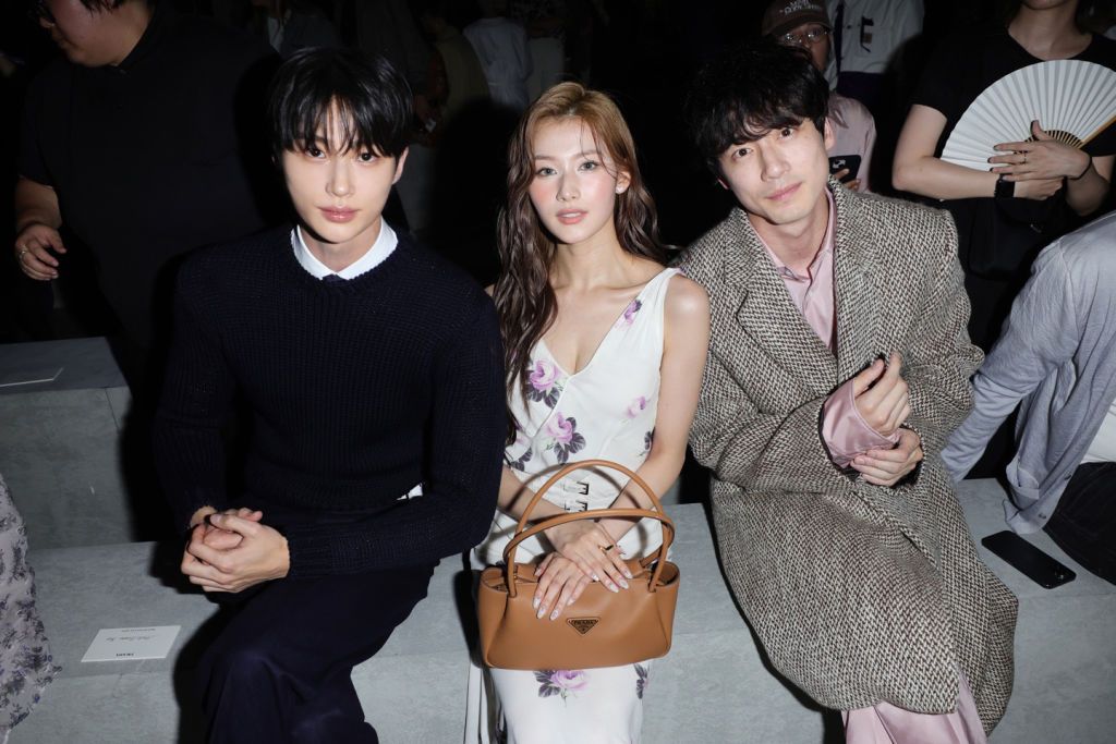 MILAN, ITALY - JUNE 16:  (EDITOR’S NOTE: Image has been retouched at the request of the subjects Byeon Woo-seok and Sana) (L-R) Byeon Woo-seok, Sana and Kentaro Sakaguchi attend the Prada Spring/Summer 2025 Menswear Fashion Show on June 16, 2024 in Milan, Italy. (Photo by Jacopo M. Raule/Getty Images for Prada)