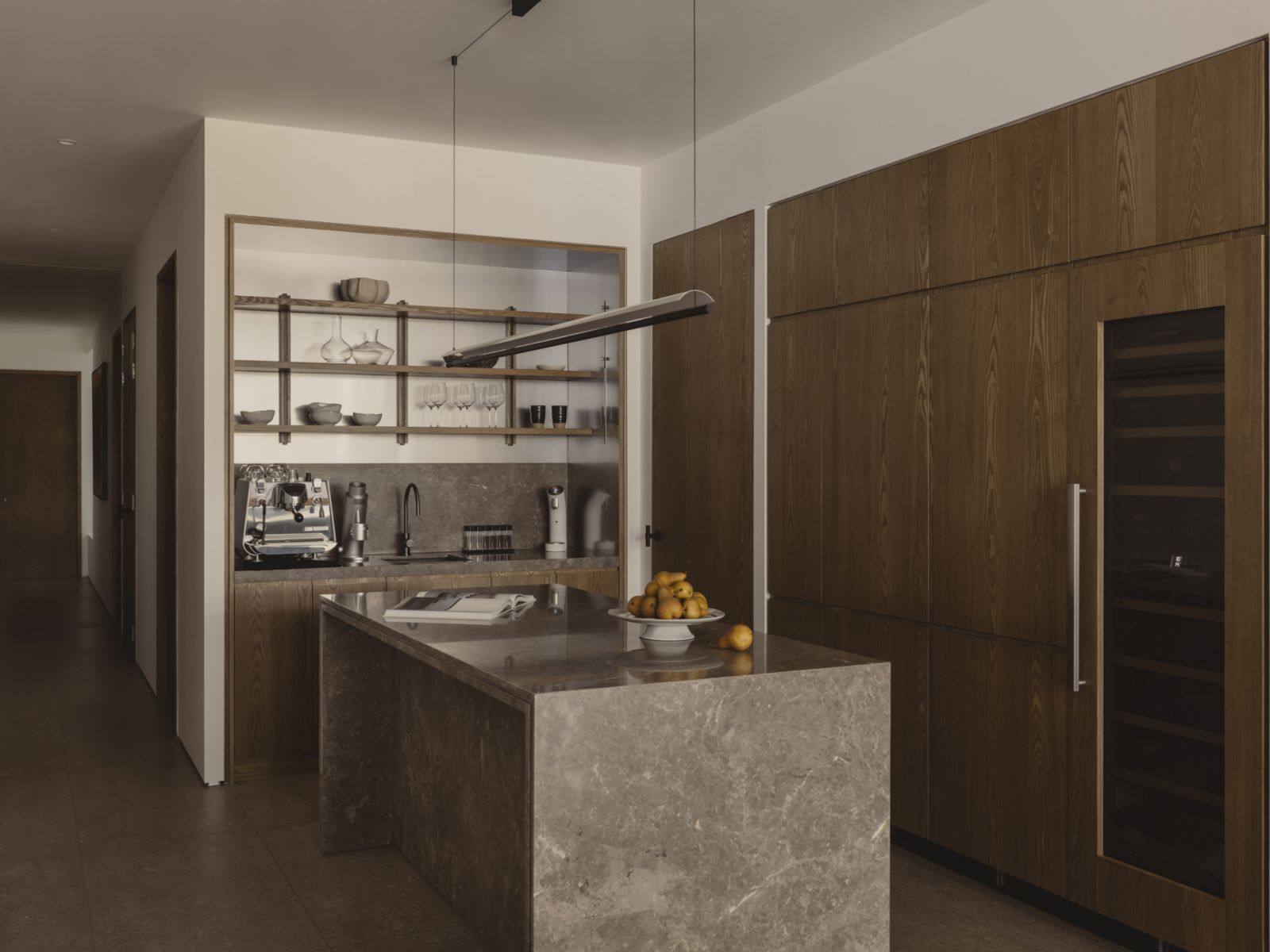 The dry kitchen incorporates alnut timber cabinetry, with a wine fridge tucked to the side