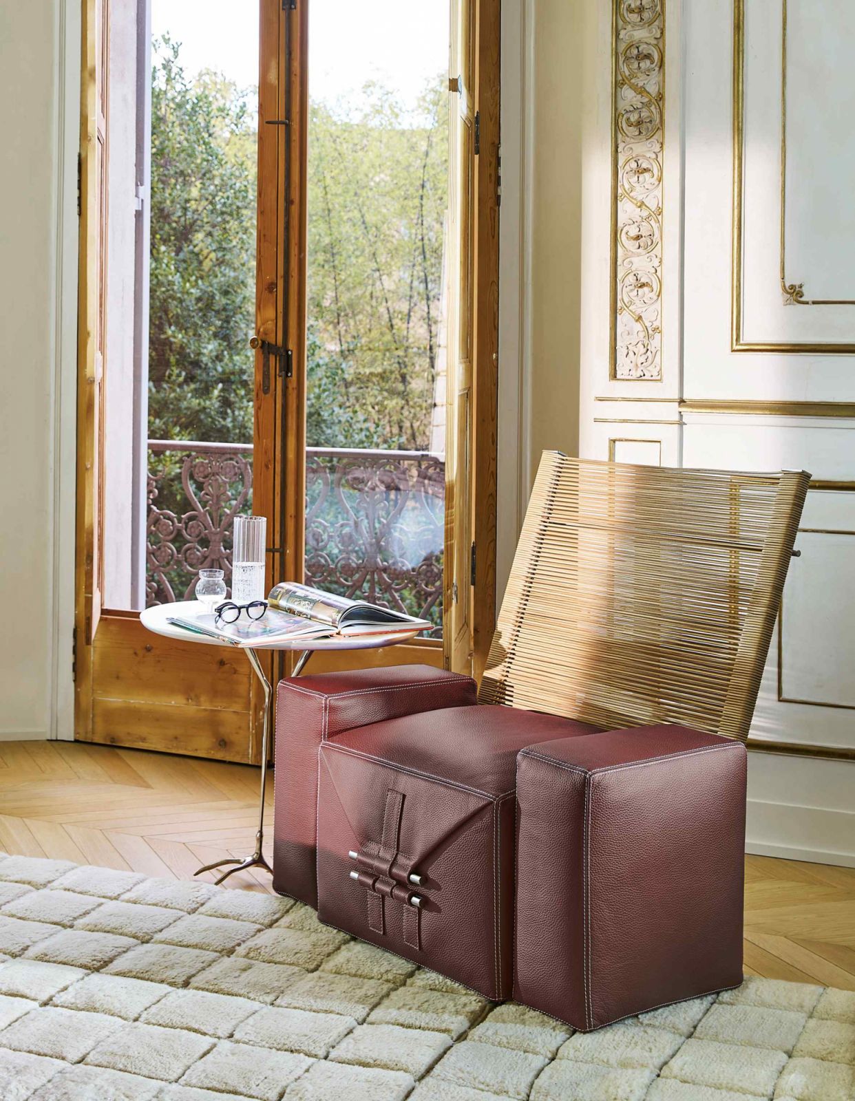 The armchair variation features a hand-woven natural saddle leather backrest