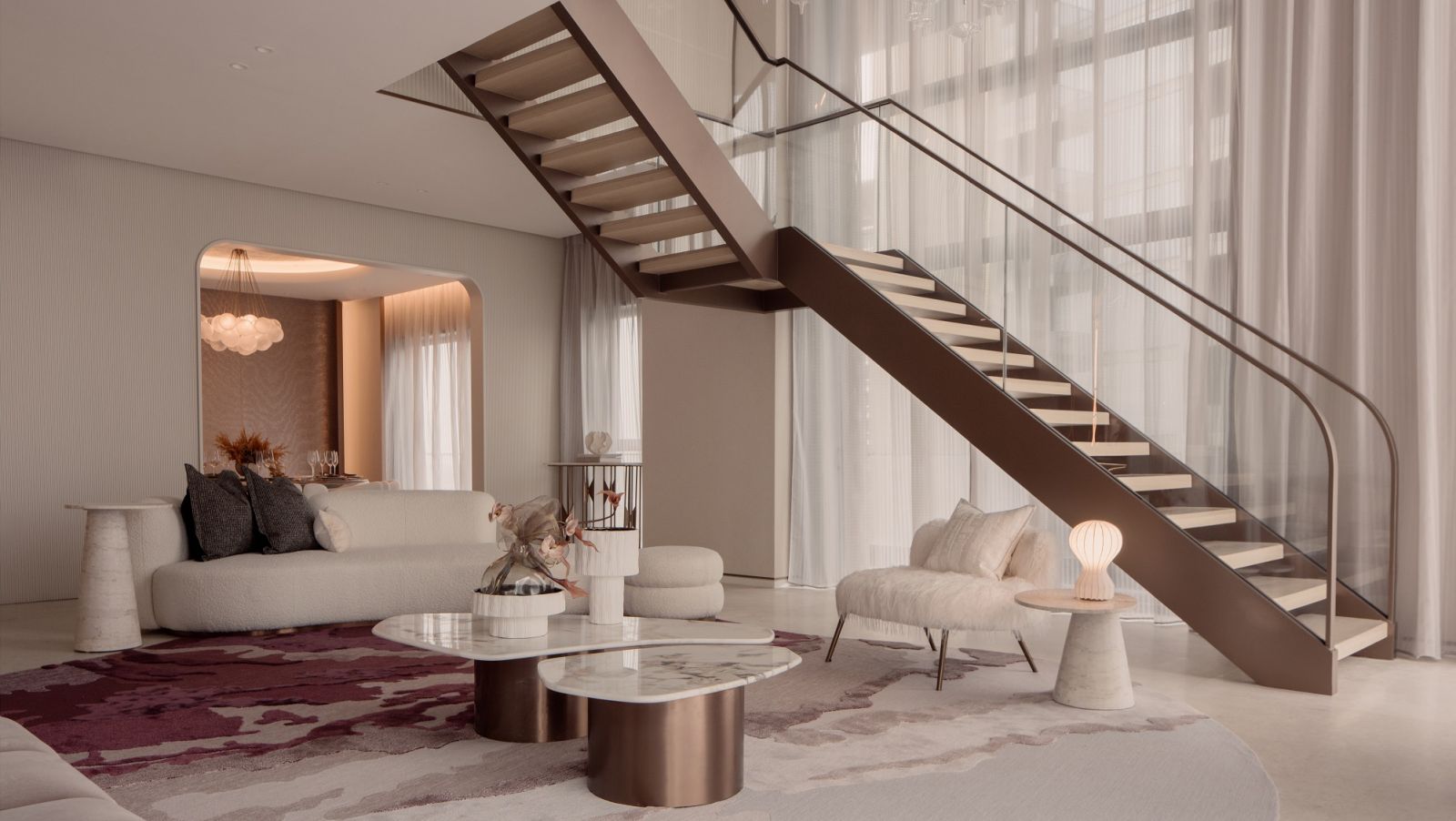 The penthouse's living area is decked out in peach, soft pink, and rose-gold tones