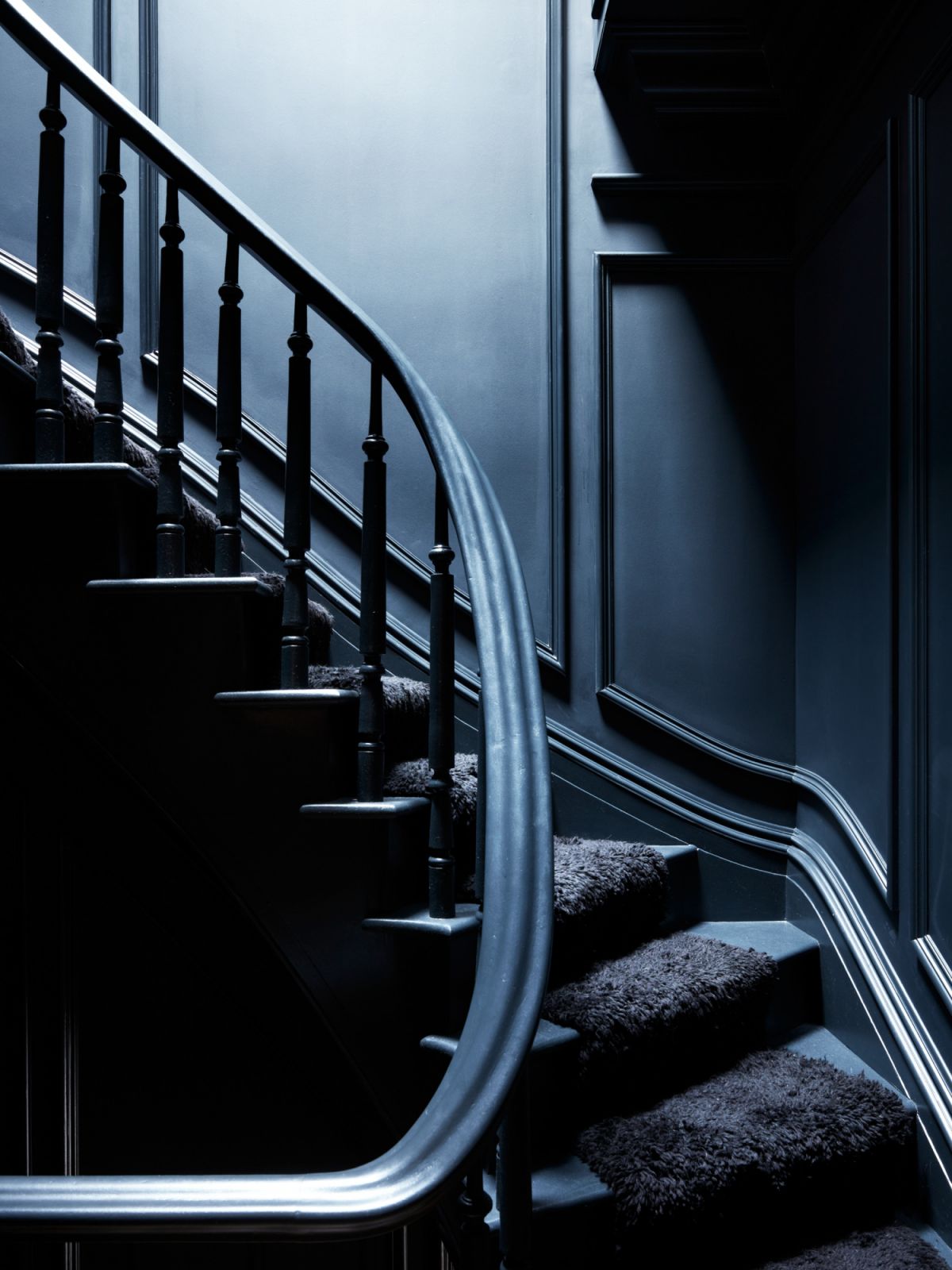 The black stairwell with wall mouldings in the four-storey home