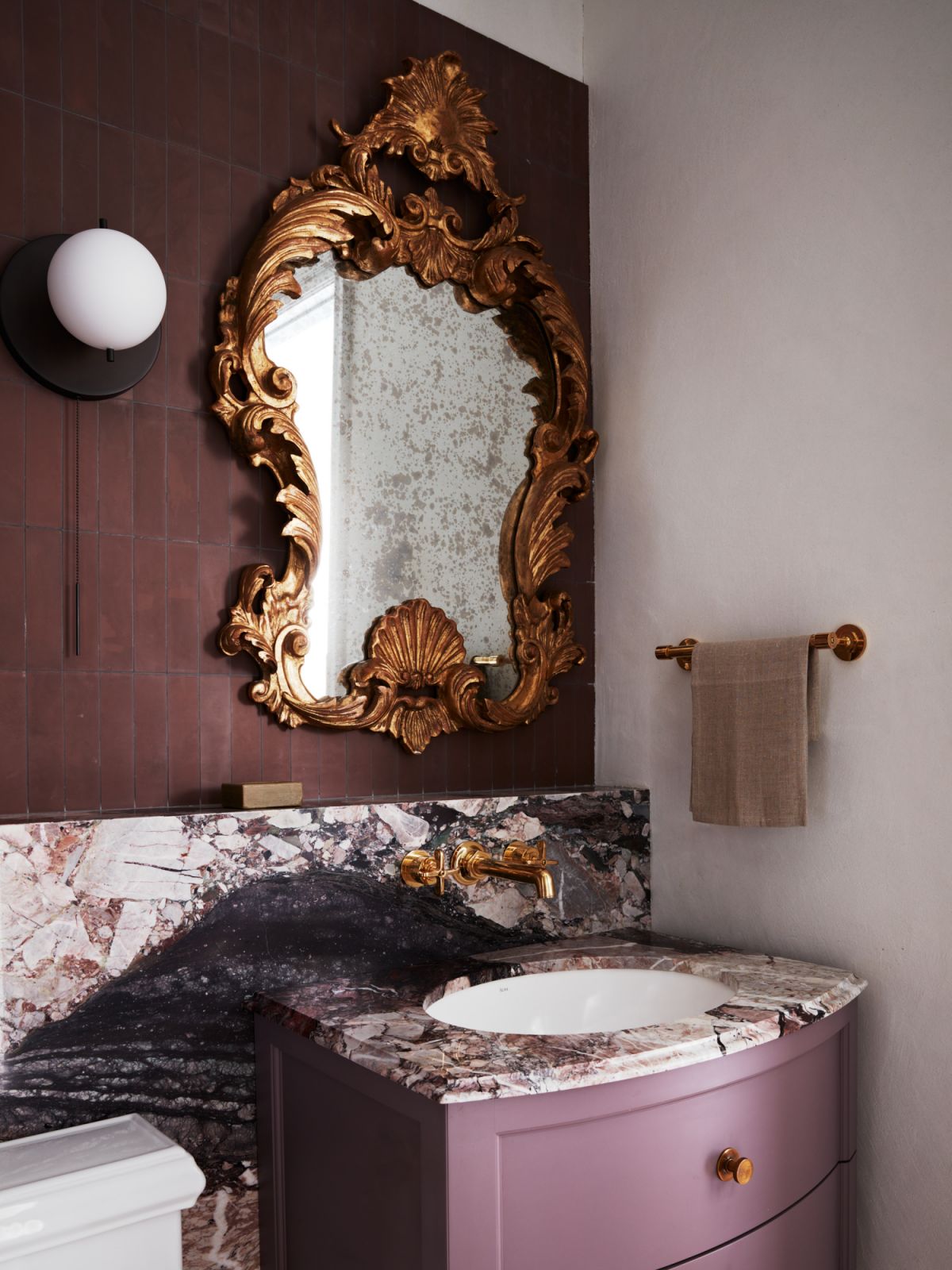 Another ensuite bathroom gilded with an ornate mirror and marble