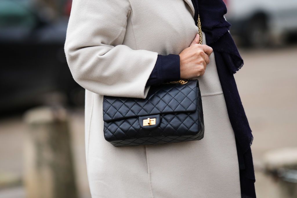 PARIS, FRANCE - JANUARY 24: A guest wears a navy blue wool scarf, a pale gray long wool coat, a black shiny leather 2.55 crossbody bag from Chanel , outside Chanel, during Paris Fashion Week - Haute Couture Spring Summer, on January 24, 2023 in Paris, France. (Photo by Edward Berthelot/Getty Images)