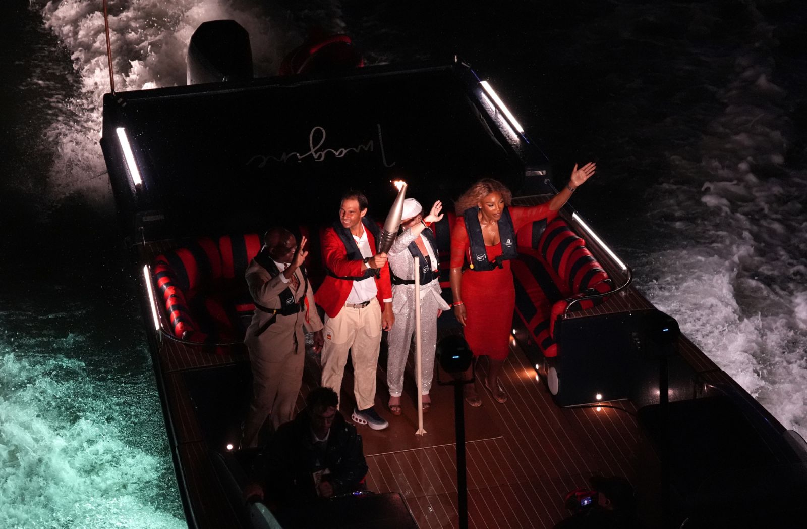 Carl Lewis, Rafael Nadal with the Olympic Flame, Nadia Comaneci and Serena Williams on a boat on the Seine during the opening ceremony of the Paris 2024 Olympic Games in France. Picture date: Friday July 26, 2024. (Photo by Martin Rickett/PA Images via Getty Images)