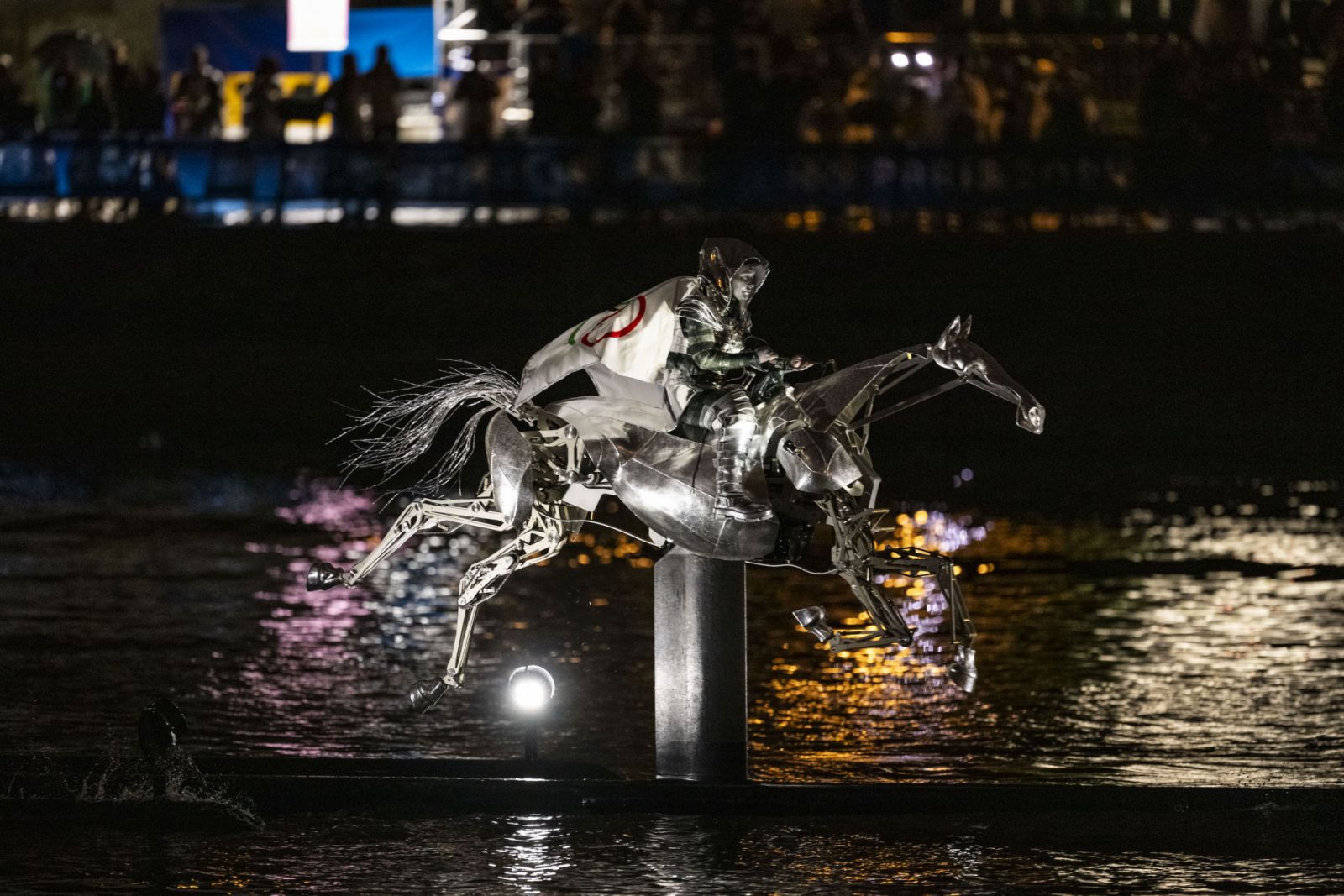 PARIS, FRANCE - JULY 26: The Horsewoman, wearing the Flag of the International Olympic Committee (IOC), is seen on a Metal Horse on the River Seine durin the Opening Ceremony of the Olympic Games Paris 2024 on July 26, 2024 in Paris, France. (Photo by Tom Weller/VOIGT/GettyImages)