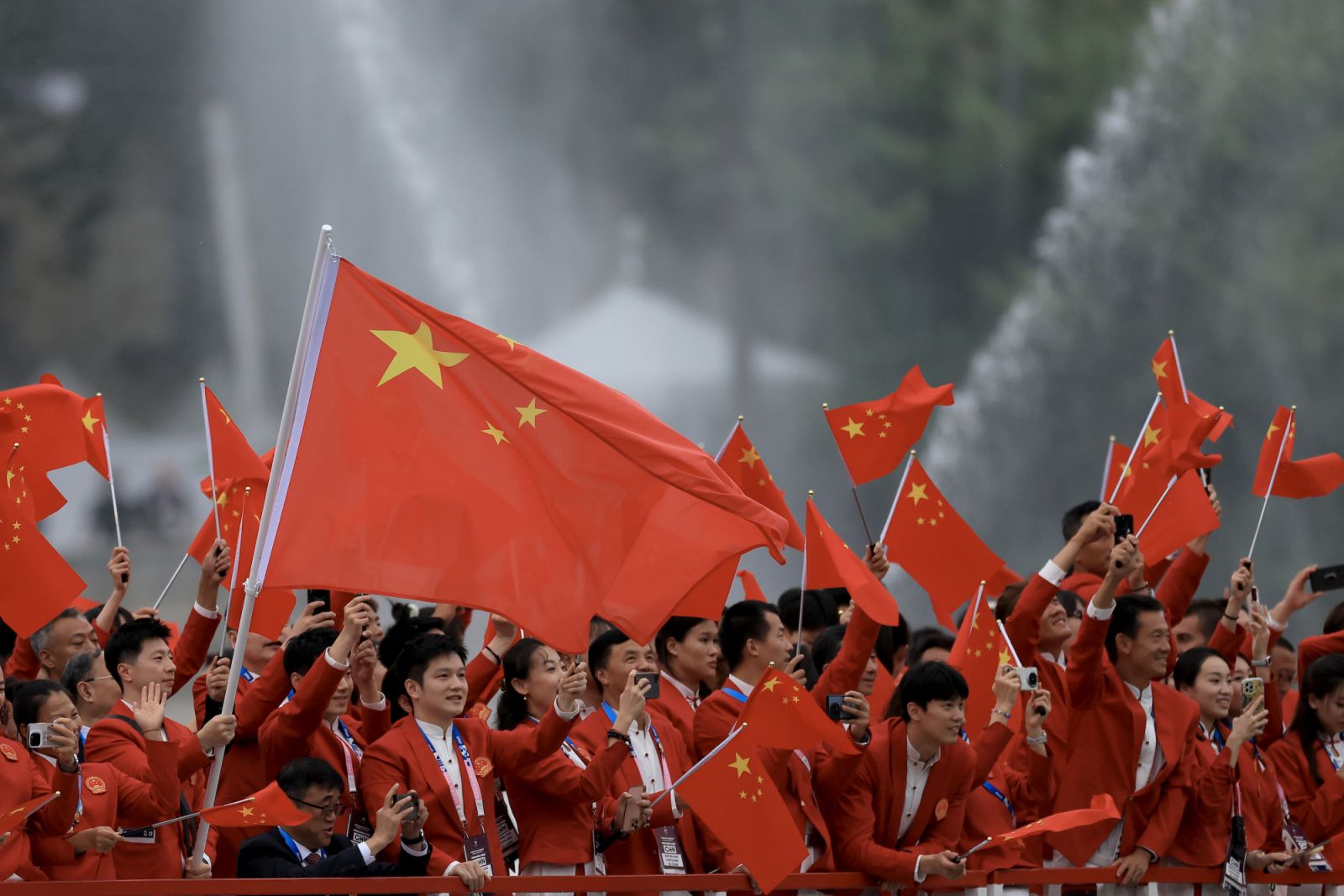 PARIS, FRANCE - JULY 26: Yu Feng and Long Ma, Flagbearers of Team People’s Republic of China, wave their flag on the team boat along the River Seine during the opening ceremony of the Olympic Games Paris 2024 on July 26, 2024 in Paris, France. (Photo by Maja Hitij/Getty Images)