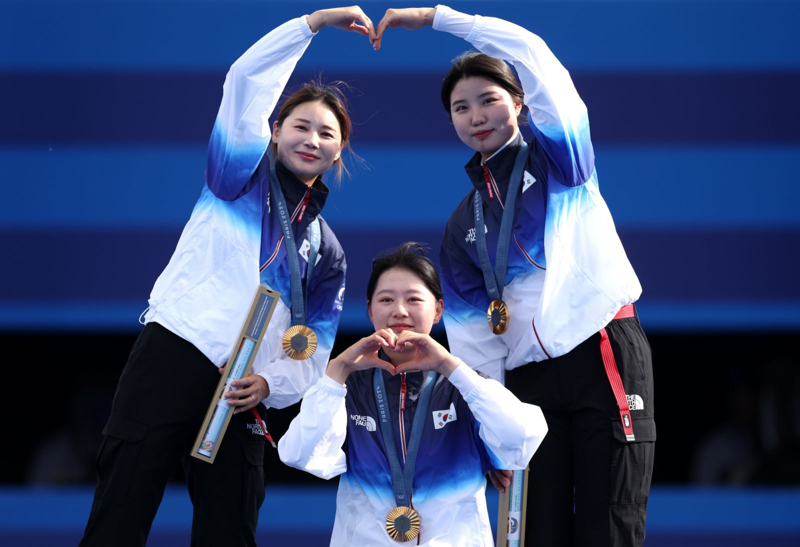 PARIS, FRANCE - JULY 28: Gold medalists Hunyoung Jeon, Sihyeon Lim and Suhyeon Nam of Team Republic of Korea pose on the podium during the Archery medal ceremony after the Women’s Team event on day two of the Olympic Games Paris 2024 at Esplanade Des Invalides on July 28, 2024 in Paris, France. (Photo by Alex Pantling/Getty Images)
