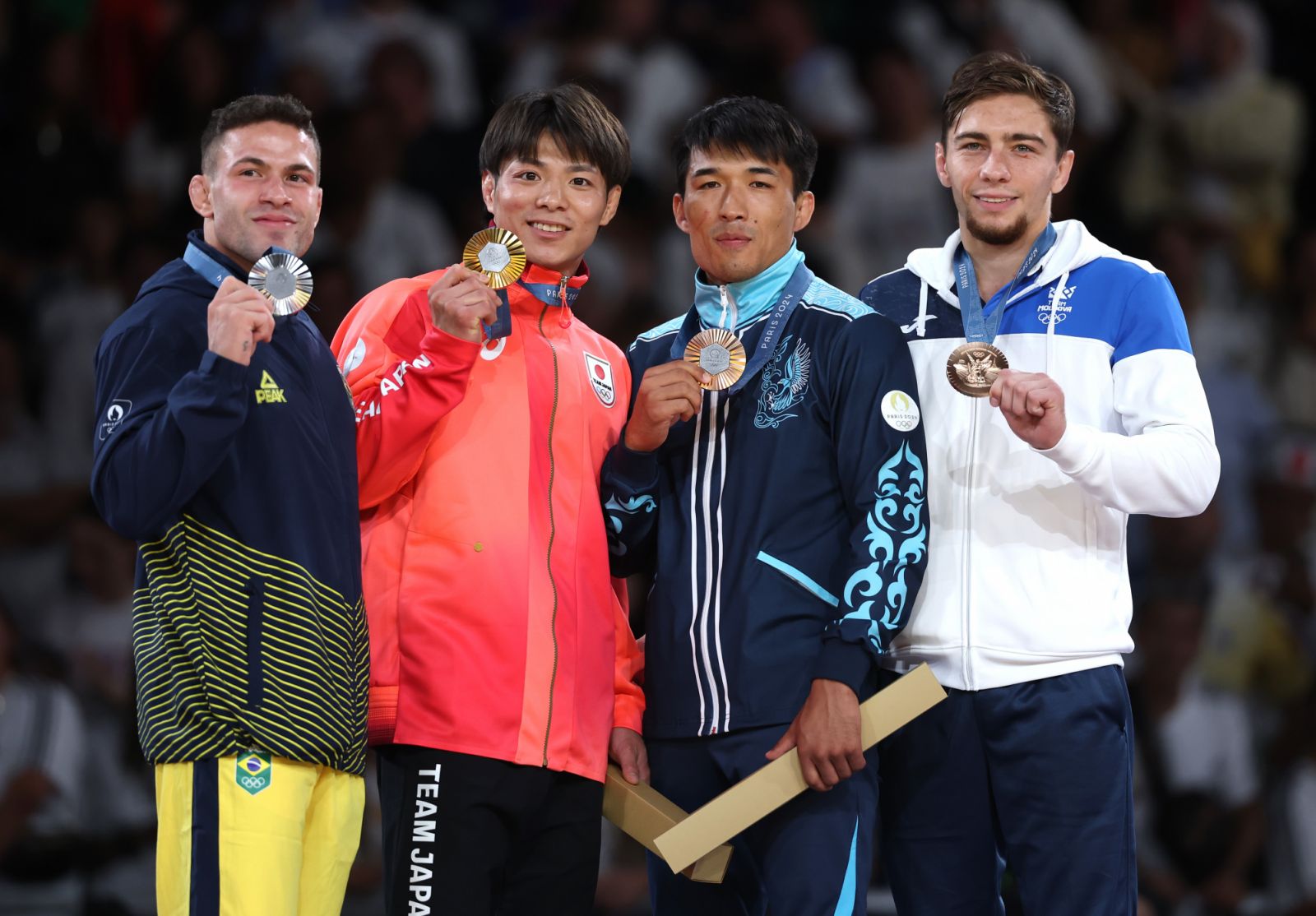 PARIS, FRANCE - JULY 28: Gold medalist Hifumi Abe of team Japan (C), Silver medalist Willian Lima of Team Brazil (L) and Bronze medalists Denis Vieru of Team Republic of Moldova and Gusman Kyrgyzbayev of Team Kazakhstan (R) pose for a photo on the podium during the Men -66 kg tournament on day two of the Olympic Games Paris 2024 at Champs-de-Mars Arena on July 28, 2024 in Paris, France. (Photo by Michael Reaves/Getty Images)