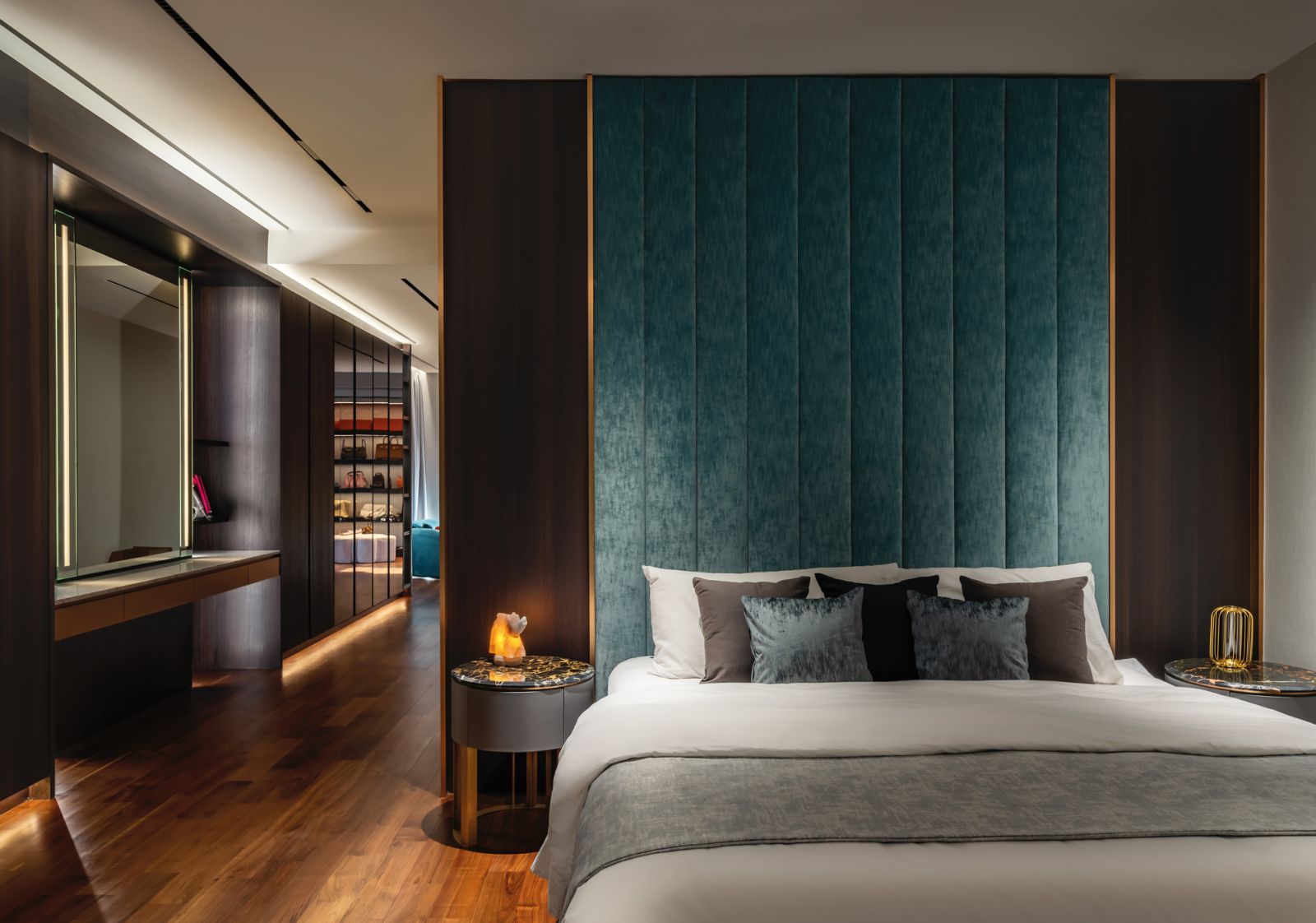 A fabric-clad wall feature in teal and accents of gold bring tactility and luxury to the master bedroom