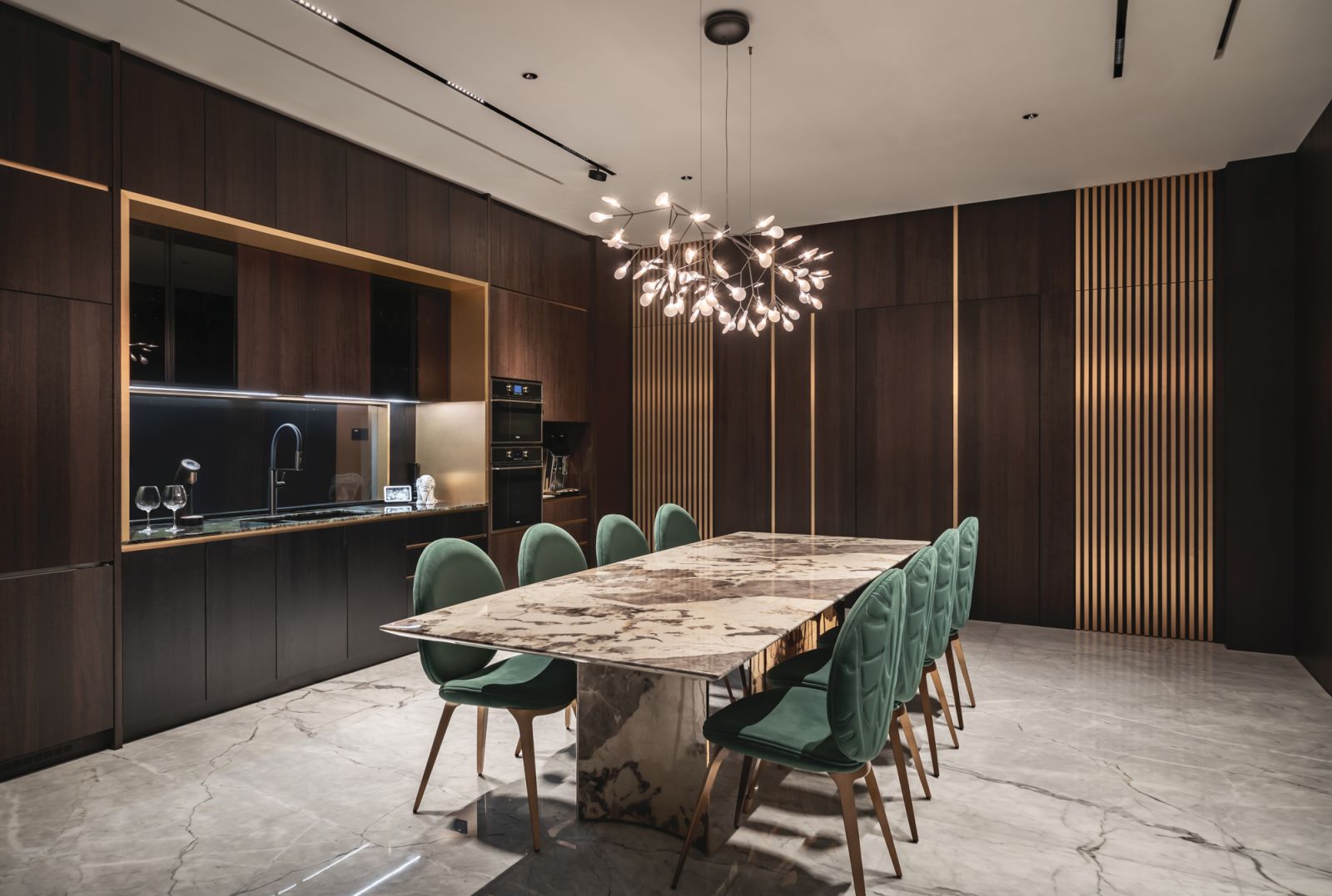 At one end of the dining area and dry kitchen is a pair of “hidden” doors flush with the wall cladding and masked by gold strips; one leads to the wet kitchen and the other to the helper’s room